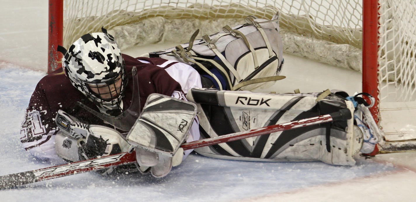 Girls State Hockey Tournament, Class A Championship, Breck vs. South St. Paul. 2/25/12. (left to right) Breck's Leah Schwartzman's shot went high on South St. Paul's goalie Sydney Conley for the game winning score in overtime.] Bruce Bisping/Star Tribune bbisping@startribune.com. Leah Schwartzman, Sydney Conley/program. ORG XMIT: MIN2013103015021756