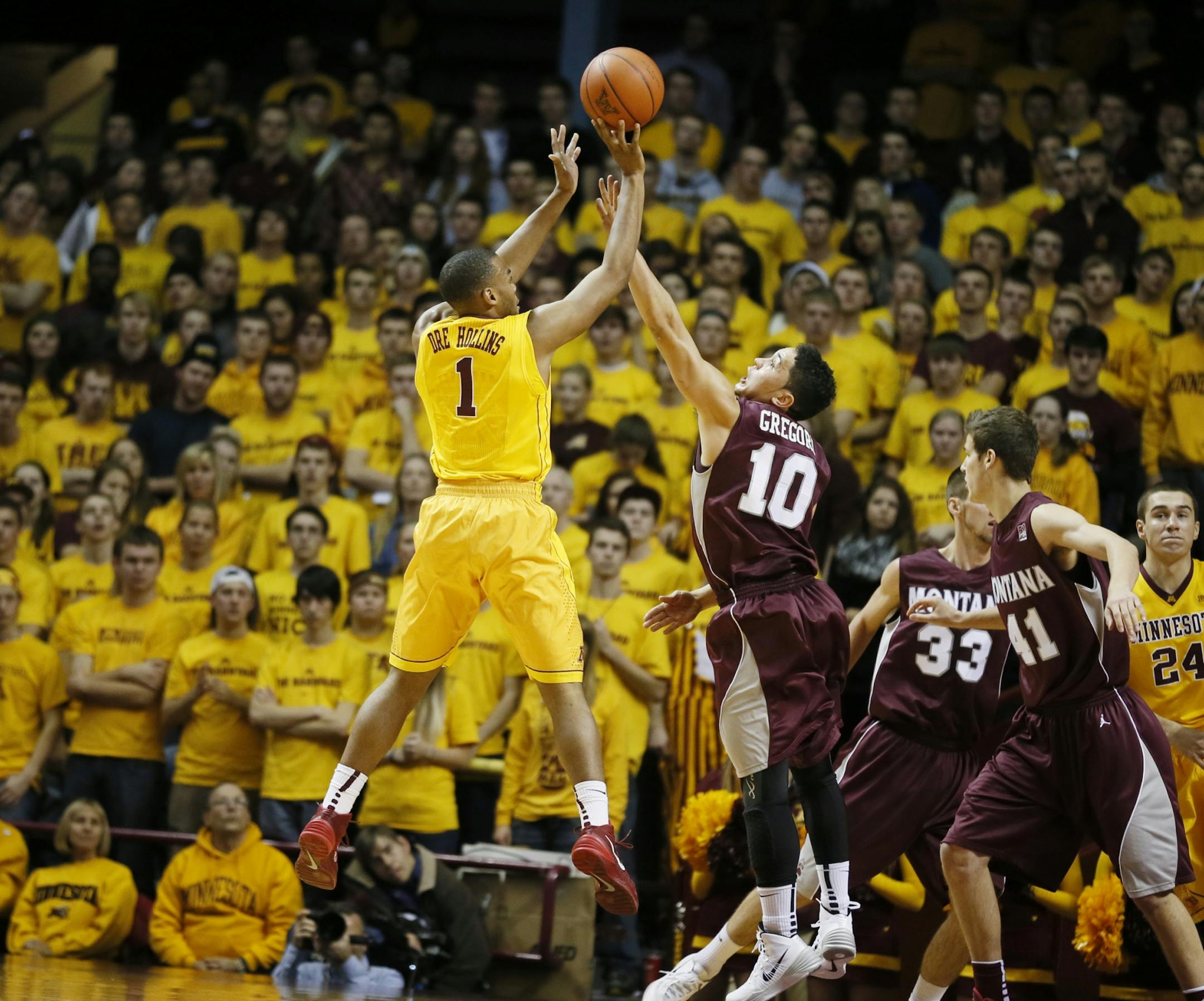 Minnesota Gophers guard Andre Hollins (1) scored over Montana Grizzlies guard Jordan Gregory (10) during NCAA basketball action between Minnesota and Montana at Williams Arena Tuesday November 12, 2013.