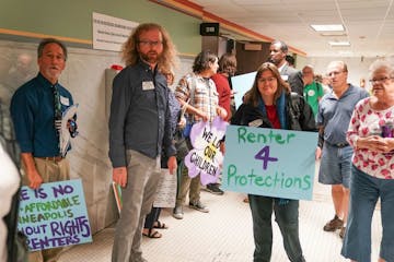 Renters advocacy groups passed out signs outside Minneapolis Council chambers before a hearing on the tenant screening ordinance in August.