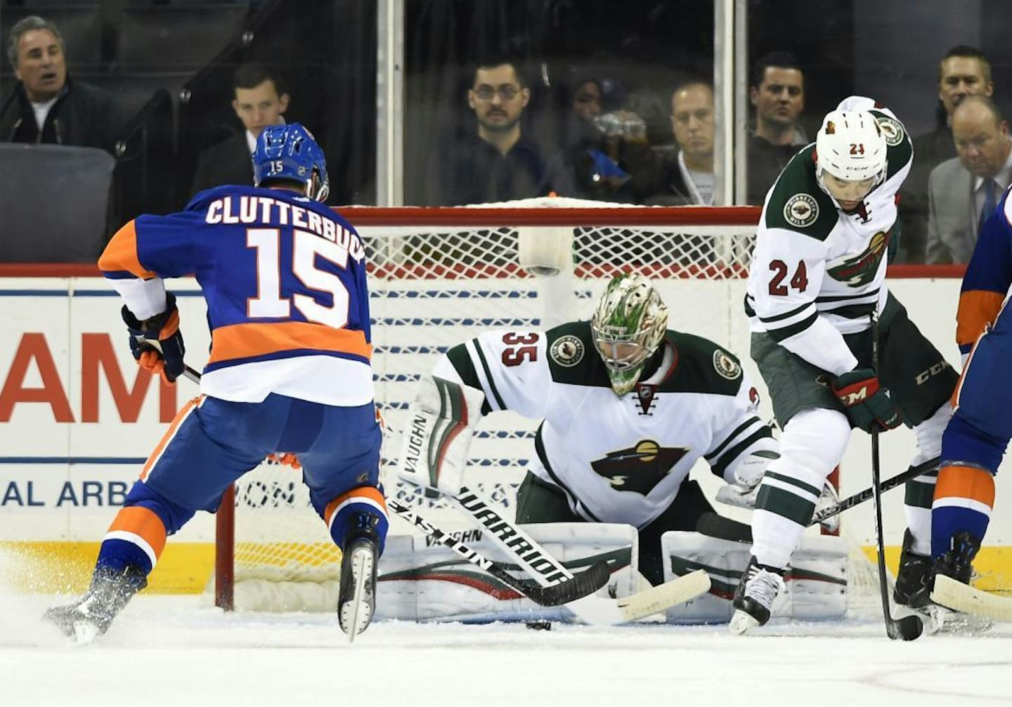 Wild goalie Darcy Kuemper and defenseman Matt Dumba (24) defended the net against Islanders right winger Cal Clutterbuck (15) in the first period Sunday.