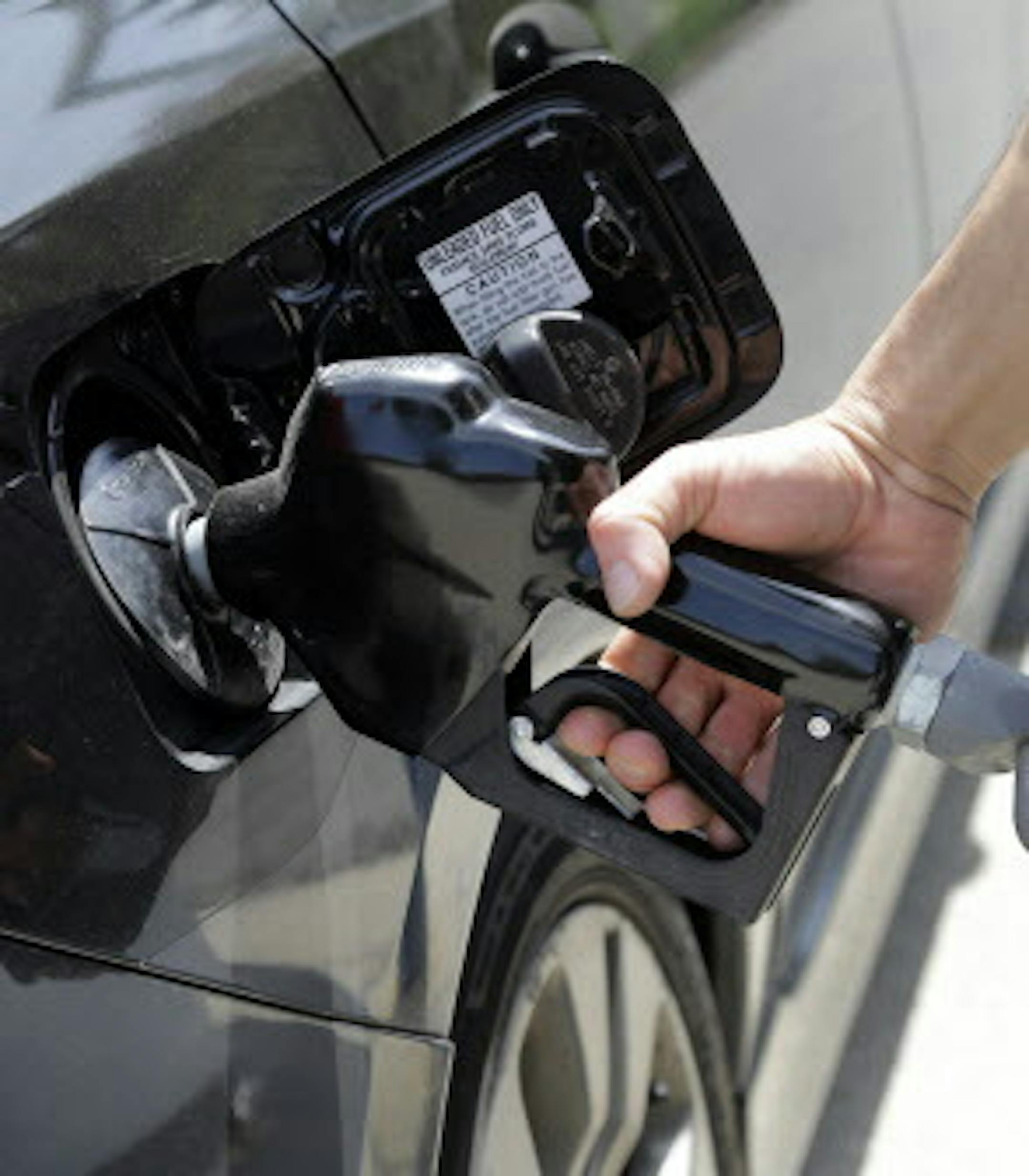 FILE - In this May 8, 2015, file photo, gas station attendant Carlos Macar pumps gas in Andover, Mass. Oil prices have plummeted over the last year, a result of high global supplies and weaker demand than expected. U.S. drivers are paying less than $2 a gallon on average for the first time since the Great Recession. (AP Photo/Elise Amendola, File)