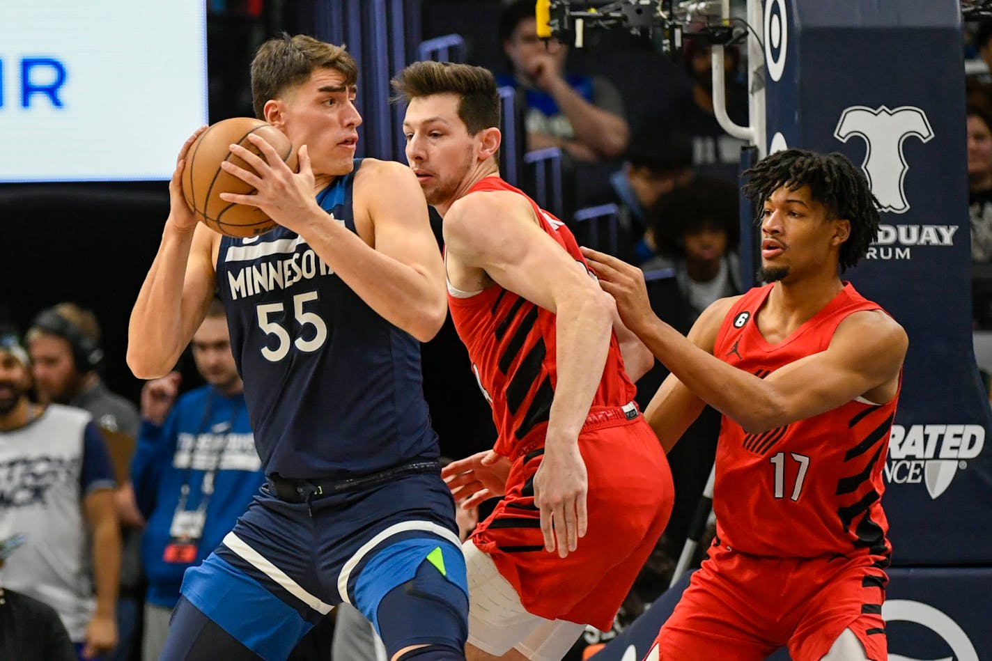 Minnesota Timberwolves center Luka Garza (55) is defended by Portland Trail Blazers center Drew Eubanks, center and guard Shaedon Sharpe (17) during the first half of an NBA basketball game, Wednesday, Jan. 4, 2023, in Minneapolis. (AP Photo/Craig Lassig)