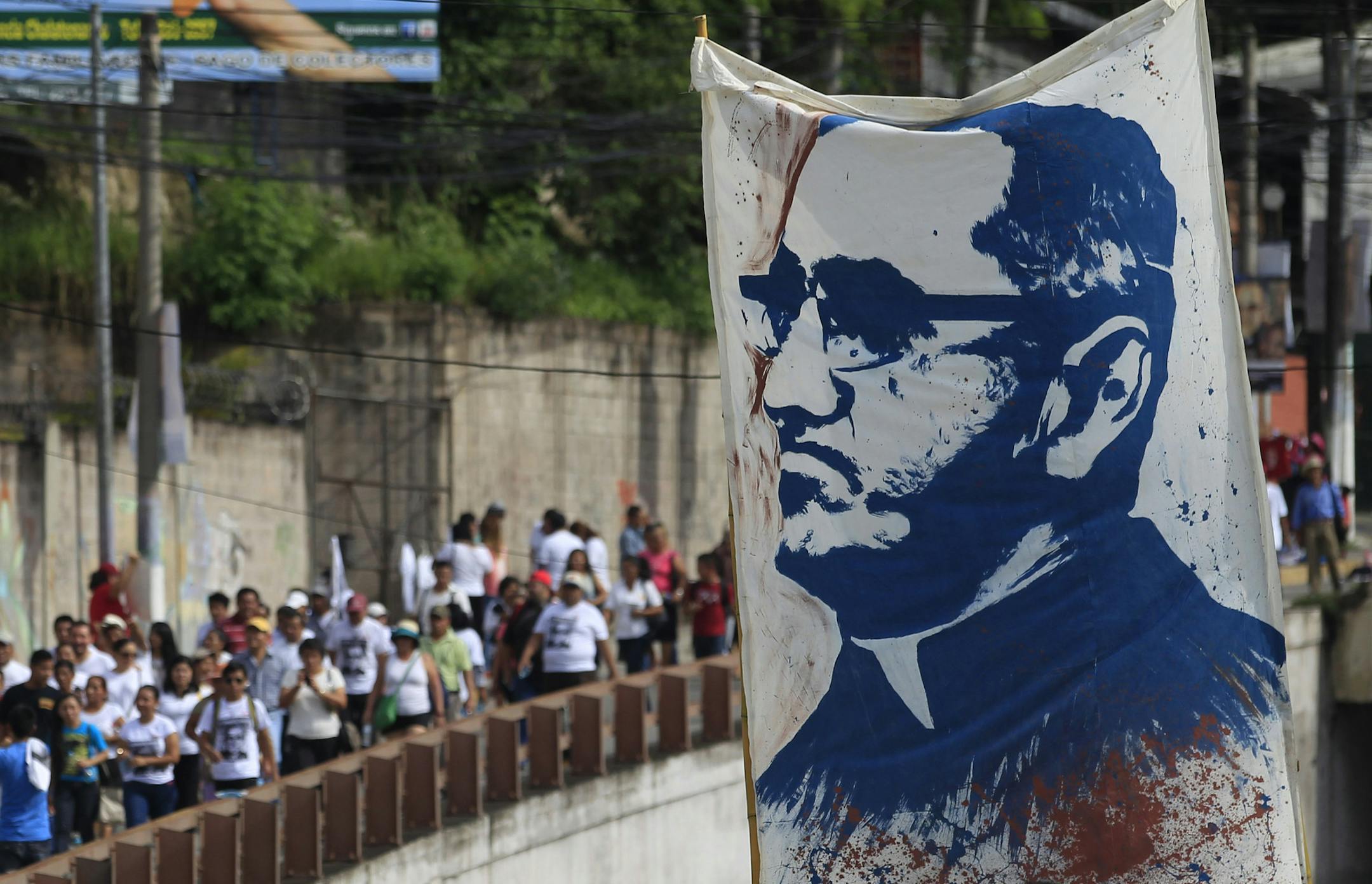 Pilgrims carry a portrait of Roman Catholic Archbishop Oscar Romero to Romero's beatification ceremony in San Salvador, El Salvador, Saturday, May 23, 2015. Huge crowds are expected at the ceremony to beatify Romero, who was cut down by an assassin's bullet 35 years ago and declared a martyr for his faith this year by Pope Francis. (AP Photo/Moises Castillo)