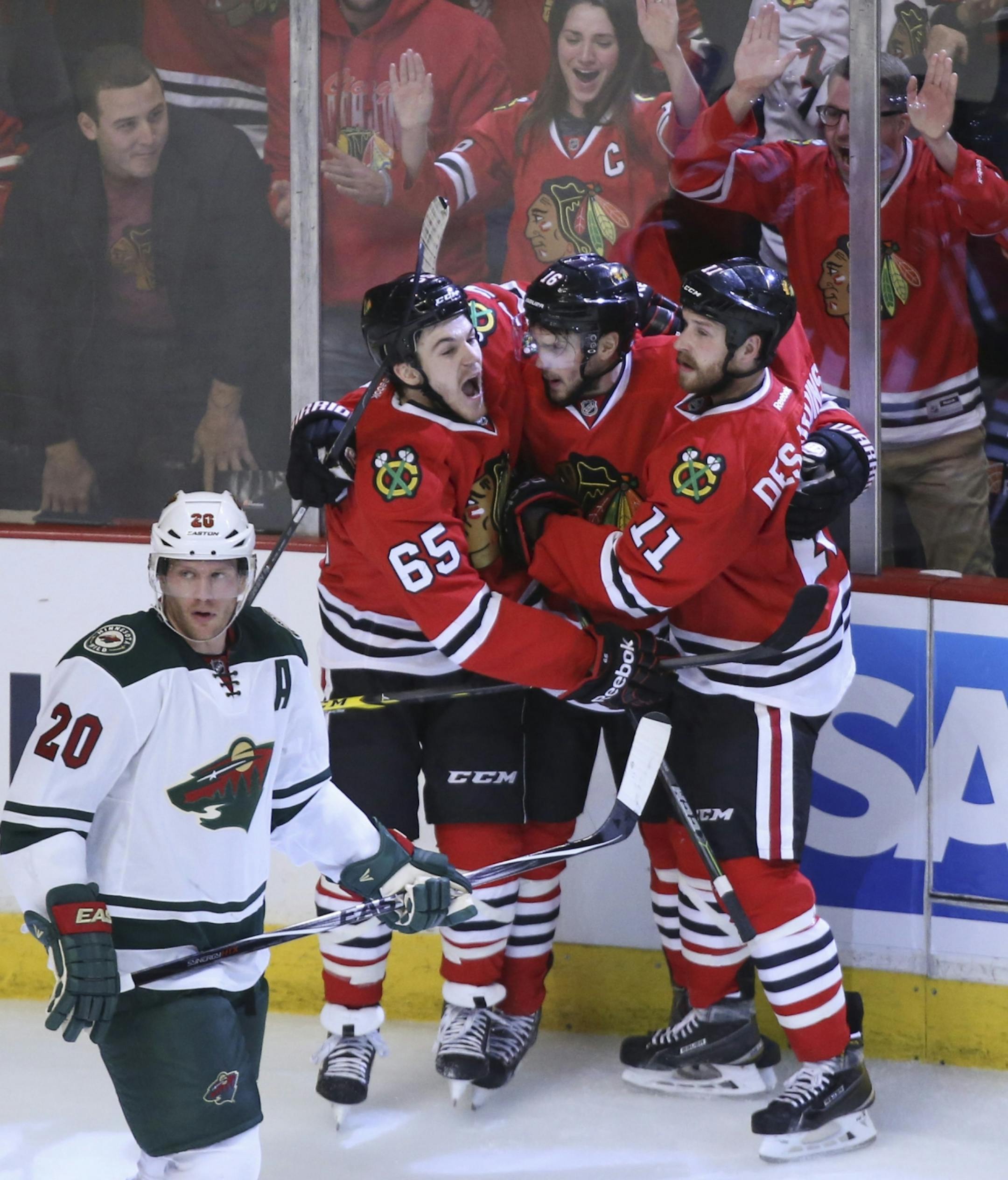 Blackhawks center Marcus Kruger (16), center was congratulated by teammates Andrew Shaw (65) and Andrew Desjardins (11) after Kruger's first period goal put Chicago ahead 3-0 Friday night.