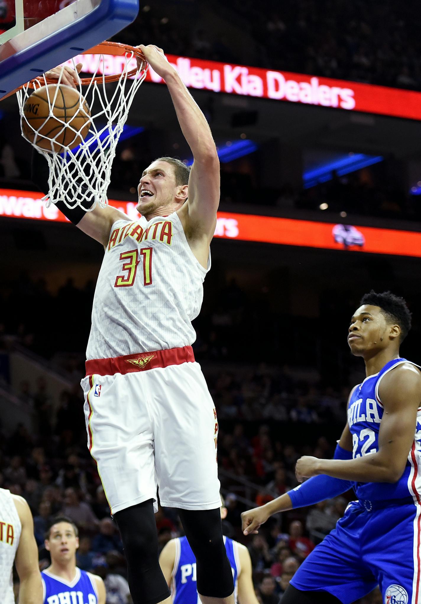 Atlanta Hawks' Mike Muscala (31) past Philadelphia 76ers' Richaun Holmes (22) during the first half of an NBA basketball game, Saturday, Oct. 29, 2016, in Philadelphia. (AP Photo/Michael Perez)