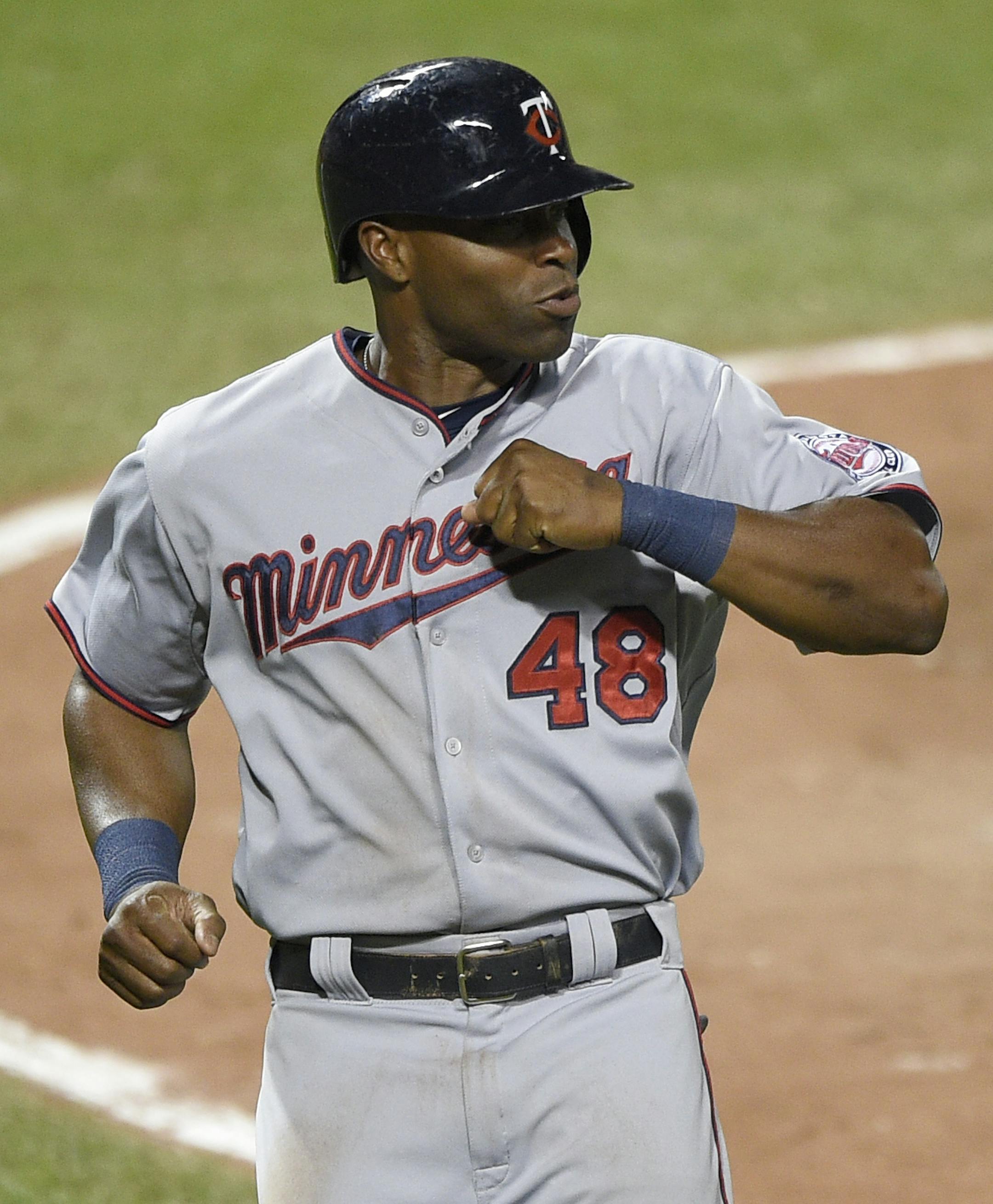 Minnesota Twins' Torii Hunter (48) celebrates with Brian Dozier (2) after Hunter scored on a single by Byron Buxton during the seventh inning of a baseball game against the Baltimore Orioles, Saturday, Aug. 22, 2015, in Baltimore. The Twins won 3-2. (AP Photo/Nick Wass)