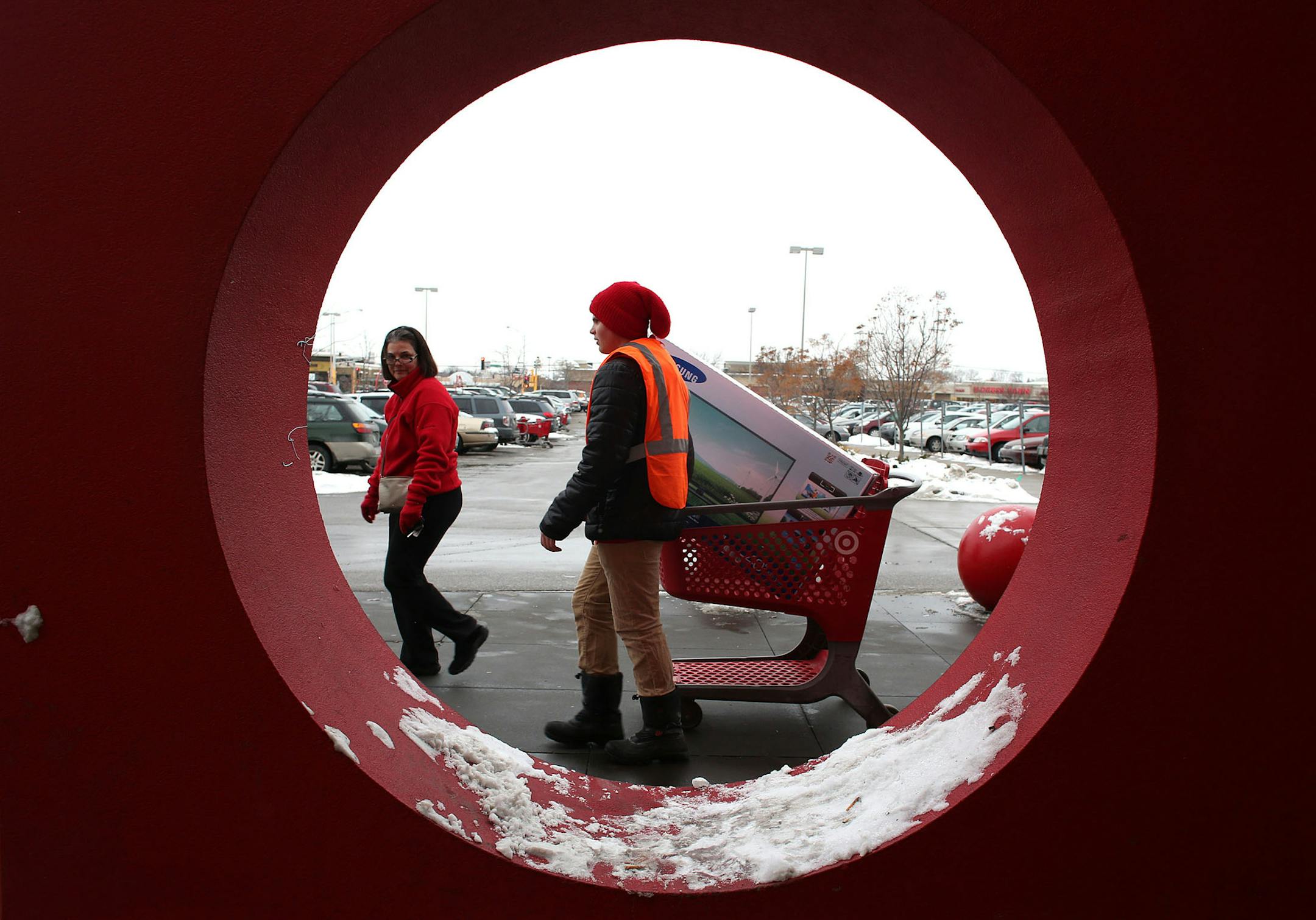 Denise Dian, of Roseville, lead Wyatt Buchanan, Target employee, to her car so that he could help her pack it in at the Target in Roseville Saturday, December 21, 2013. Dian decided to do more shopping with the 10% discount. "I always buy on sale. I would have bought that item maybe next week maybe four weeks from now, two months from now instead i bought it today, " she said. "The freezer was half full. I wasn't going to fill it up today but on sale plus, 10 plus 5% we're going to fill it up to