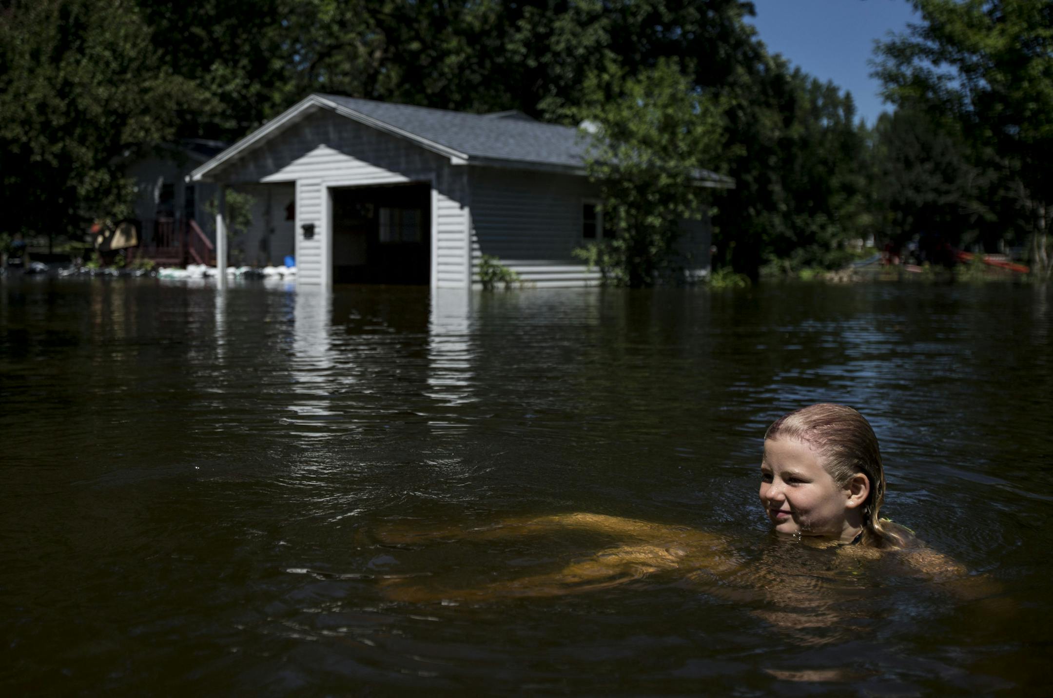 Anja Bakke swam in the middle of N. Wood St. beside flooded homes and garages. Bakke was one of many children enjoying the impromptu and unique watering hole. ] ALEX KORMANN • alex.kormann@startribune.com Mora, MN is a small rural community in central Minnesota. On Thursday 8-10 inches of rain fell in a matter of hours causing flash flooding throughout the area. But as the water drained from all over the town it caused Lake Mora and Snake River to rise rapidly and flood local streets, hig