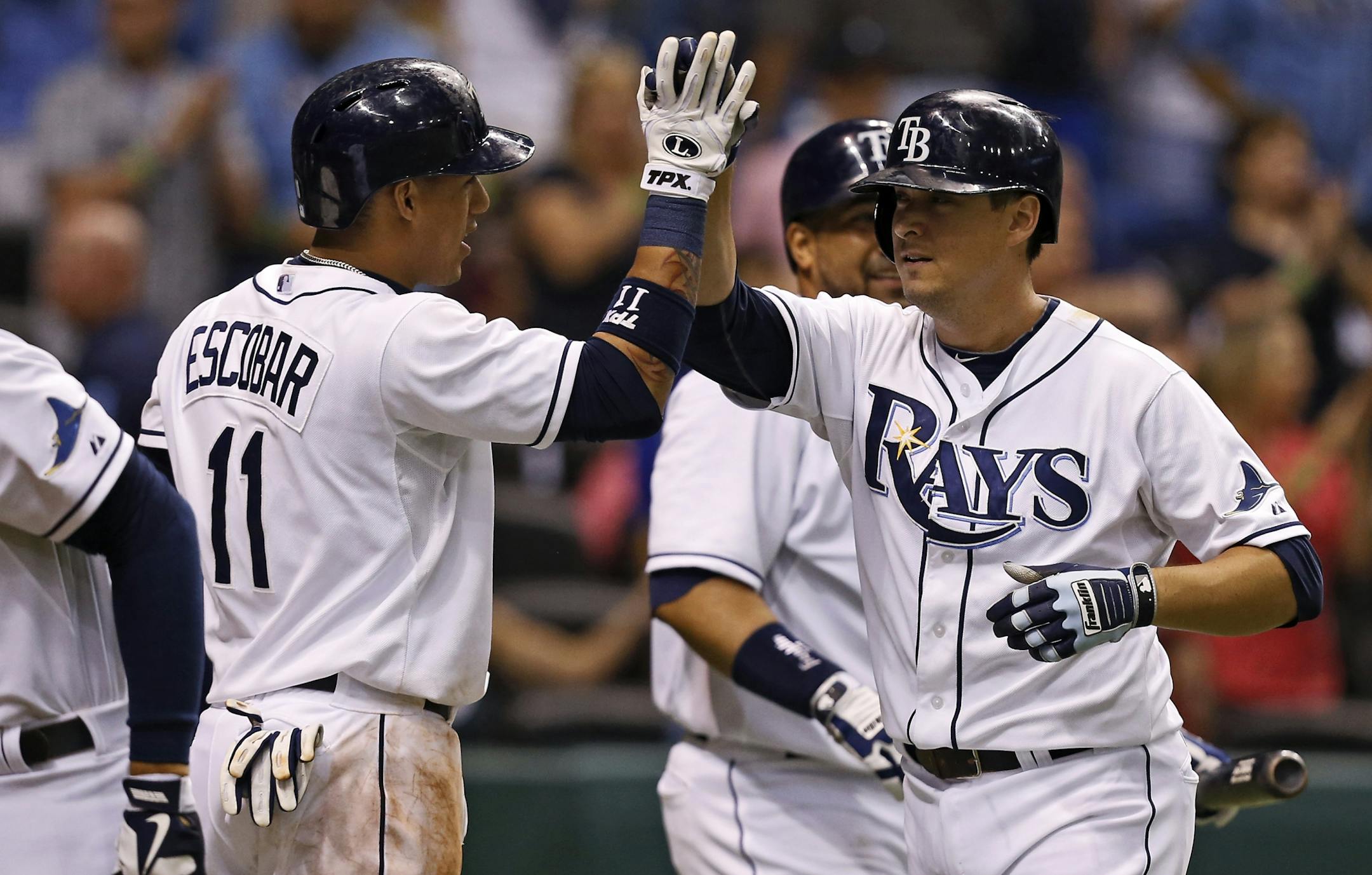 Tampa Bay Rays' Kelly Johnson, right, is congratulated by teammate Yunel Escobar after hitting a two-run home run during the sixth inning of a baseball game against the Minnesota Twins, Wednesday, July 10, 2013, in St. Petersburg, Fla.