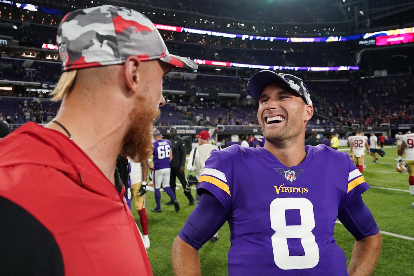 Vikings quarterback Kirk Cousins jokes with San Francisco 49ers tight end George Kittle on the field following last week's preseason game.