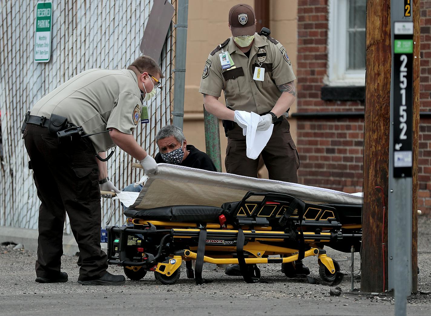 Hennepin Healthcare EMS personnel assist a man who was having trouble breathing outside the House of Charity Wednesday, May 13, 2020, in Minneapolis, MN.]