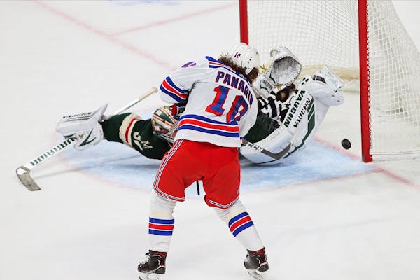 New York Rangers' Artemi Panarin, left, scores against the Wild's Alex Stalock during the shootout