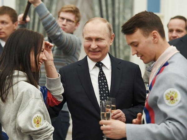 Russian President Vladimir Putin, center, toasts with Russian Paralympics Athletes who competed in the 2018 Pyeonchang Winter Paralympics, in the Krem