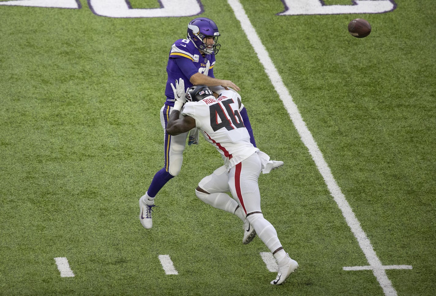 Kirk Cousins (8) is hit while throwing an incomplete pass against Atlanta.