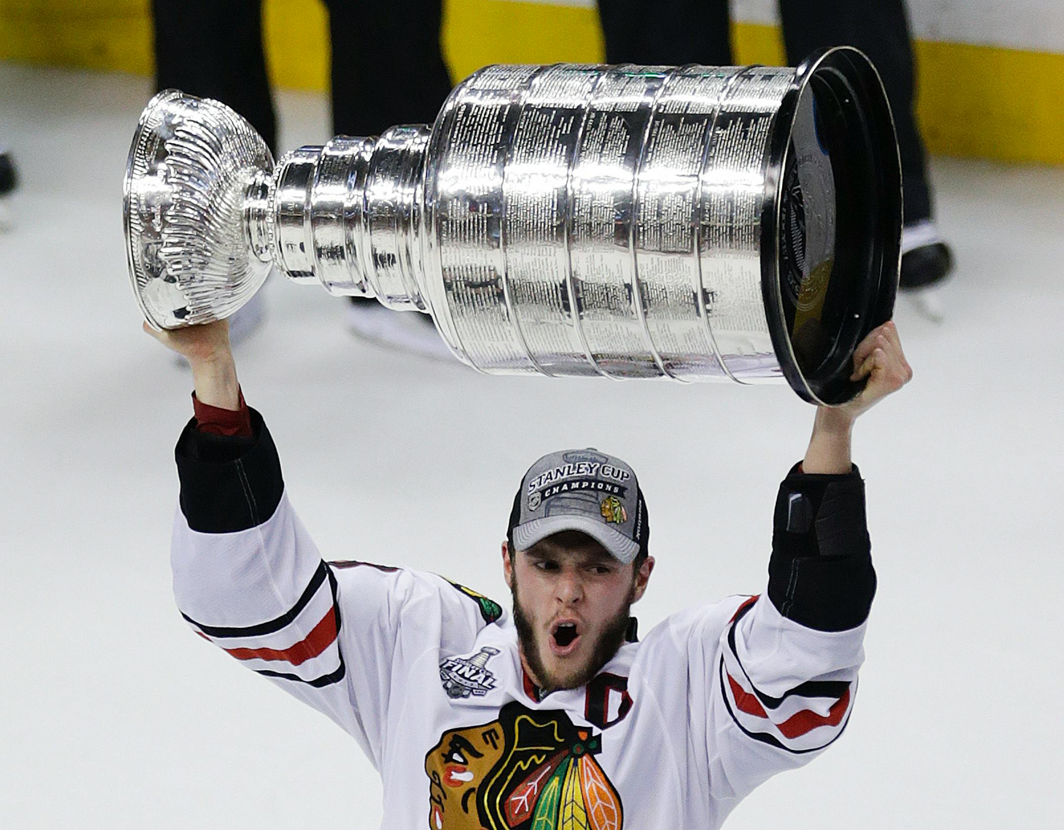 Chicago Blackhawks right wing Patrick Kane (88) hoists the Stanley Cup after beating the Boston Bruins 3-2 in Game 6 of the NHL hockey Stanley Cup Finals, Monday, June 24, 2013, in Boston. (AP Photo/Charles Krupa)