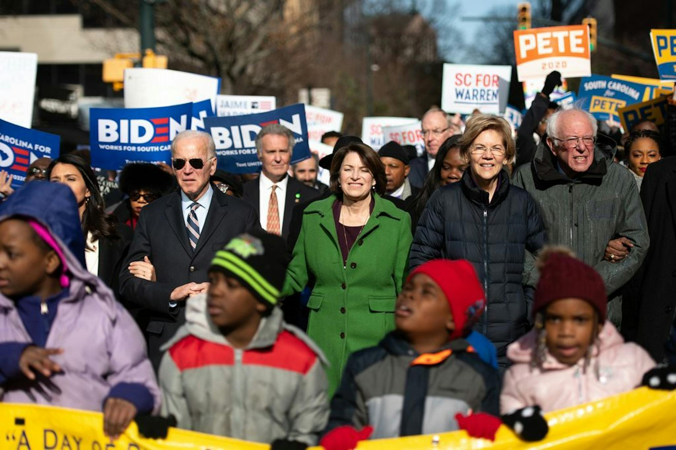 Democratic presidential candidates, former Vice President Joe Biden, left, Sen. Amy Klobuchar (D-Minn.), Sen. Elizabeth Warren (D-Mass.), and Sen. Bernie Sanders (I-Vt.), right, march down Main Street to the King Day at the Dome event on Monday, Jan. 20, 2020 in Columbia, S.C.