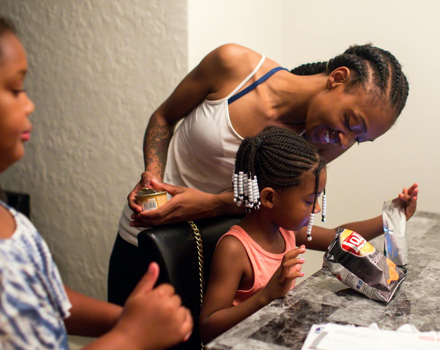 Kadaisha Tolliver gets a snack for her daughter Janiylah Little, 3, and her niece Armani Todd, 9 (left). ] NICOLE NERI &#xa5; nicole.neri@startribune.com BACKGROUND INFORMATION: Kadaisha Tolliver, her daughter Janiylah Little, 3, and their new kitten Bella in the apartment they secured after Tolliver was denied at two other places because her tenant screening record was showing a juvenile record Friday, July 12, 2019.