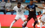 San Jose Earthquakes' Danny Hoesen fights for the ball against Minnesota United FC's Romain Métanire in the first half
