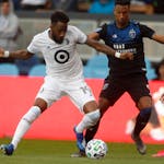 San Jose Earthquakes' Danny Hoesen fights for the ball against Minnesota United FC's Romain Métanire in the first half