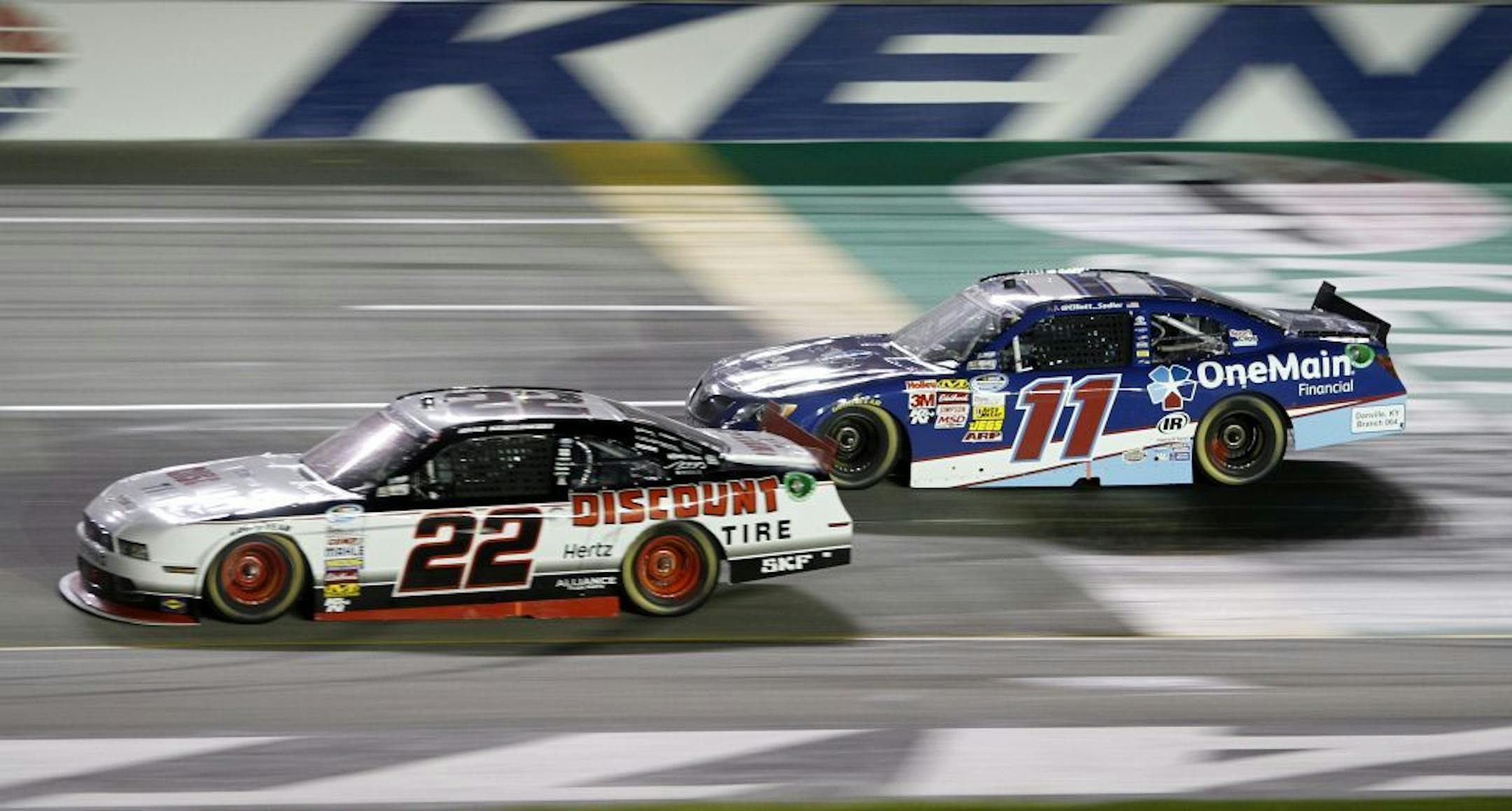 Brad Keselowski (22) pulls away from Elliott Sadler (11) on the last restart of the rain-shortened NASCAR Nationwide Series auto race at Kentucky Speedway in Sparta, Ky., Friday, June 28, 2013. Keselowski won the race.