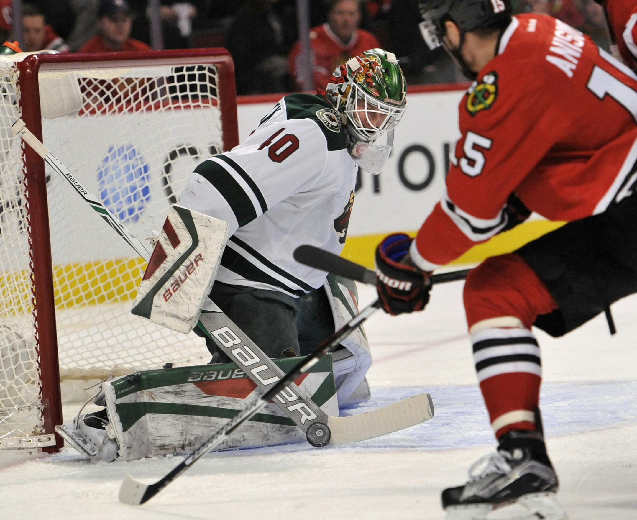 Minnesota Wild goalie Devan Dubnyk (40) makes a save against Chicago Blackhawks' Artem Anisimov (15) of Russia, during the first period of an NHL hockey game Sunday, March 20, 2016, in Chicago. (AP Photo/Paul Beaty)