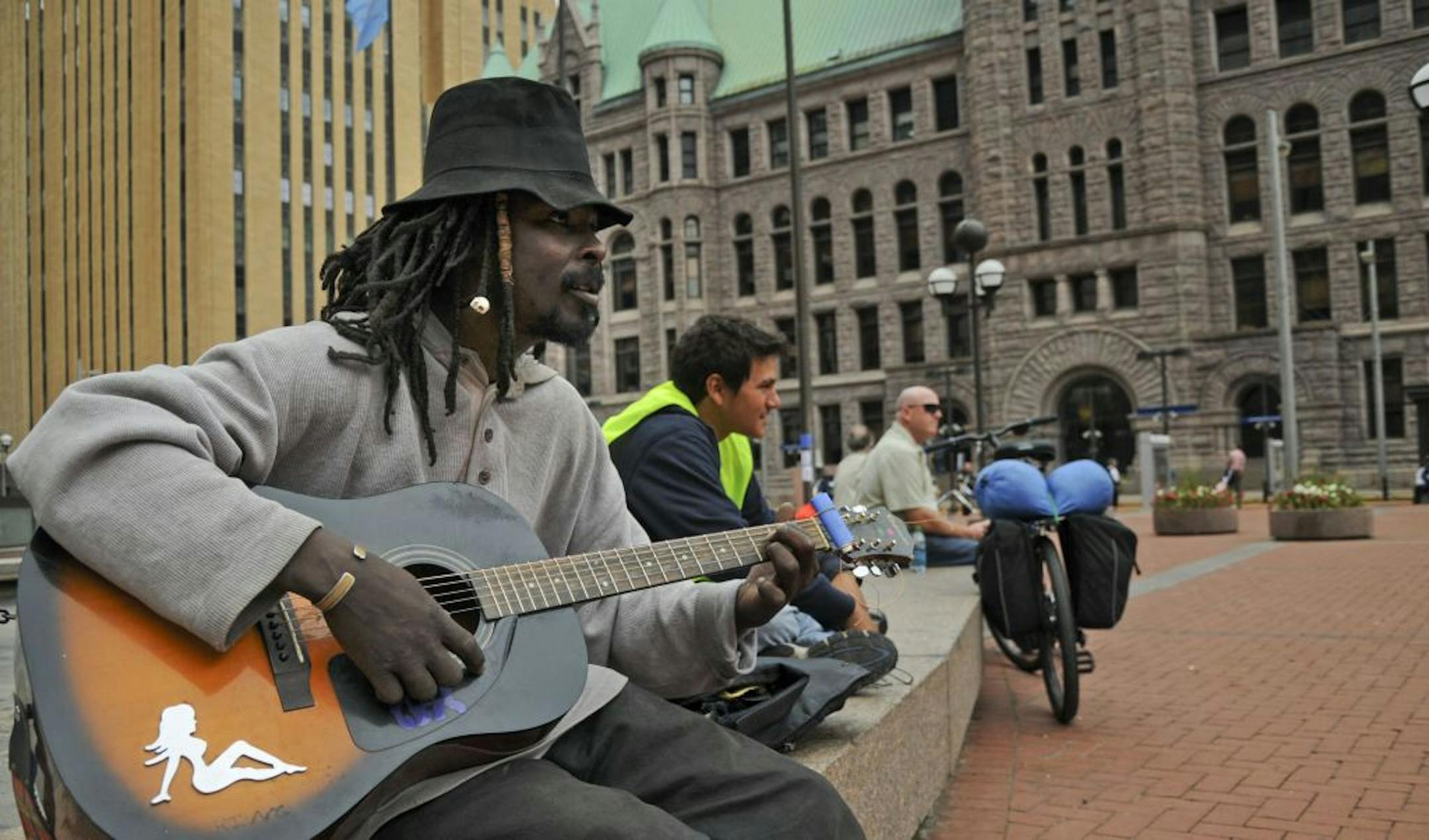 George Samuels of Minneapolis calls himself "The Monkey King." He was on hand to support his friends and played guitar at the Hennepin County Government Center Plaza as protesters gathered for a fourth day Monday.