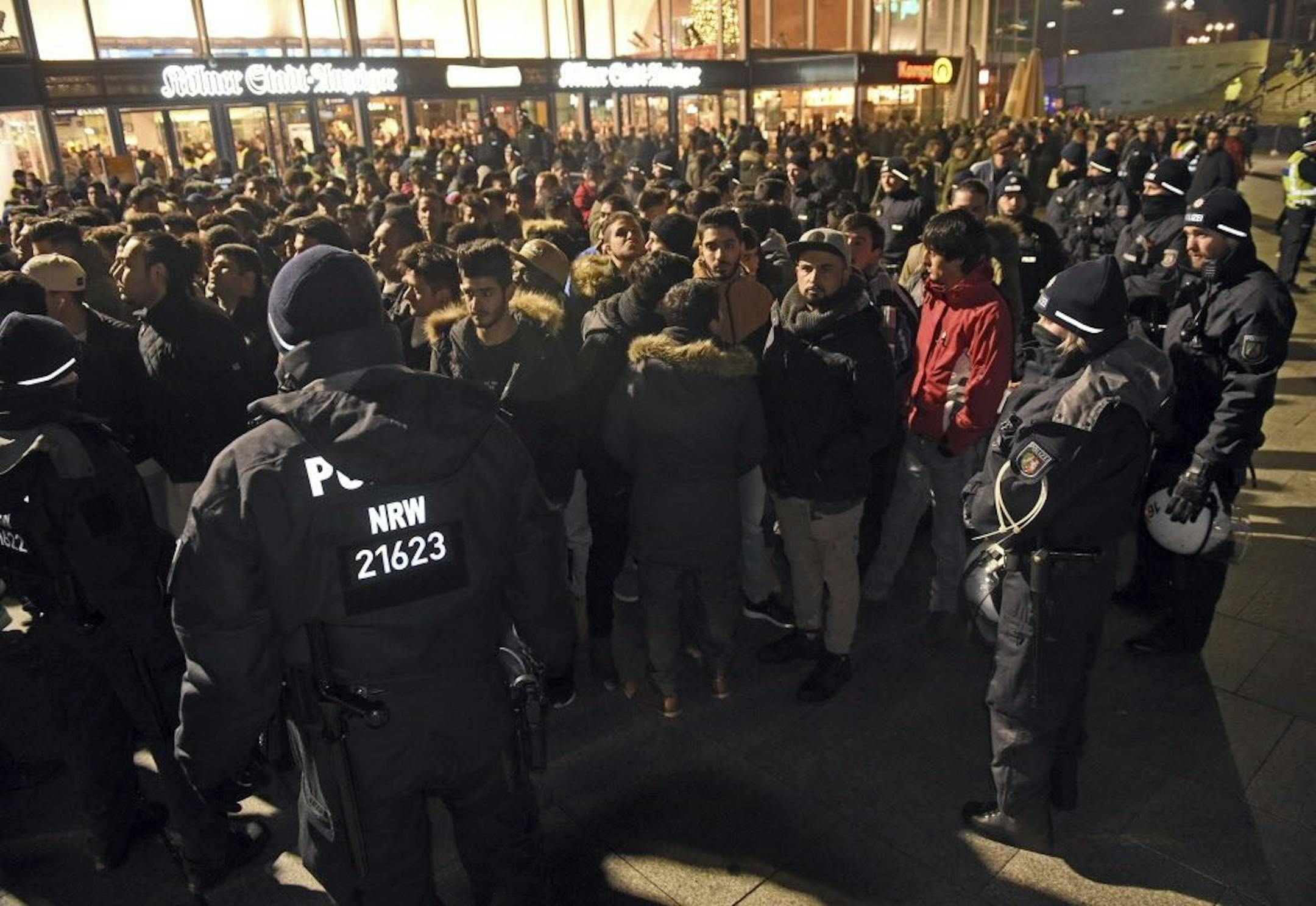 FILE - In this Dec. 31, 2016 file photo police officers surround a group of men in front of the Cologne, western Germany, main station, where a string of robberies and sexual assaults last year that were blamed largely on migrants from North Africa prompted nationwide outrage. In an interview with the Neue Osnabruecker Zeitung daily, Rainer Wendt of the DpolG union was quoted Saturday, Dec. 30, 2017, as saying the move appeared to ignore the "political dimension" in Germany, two years after hund