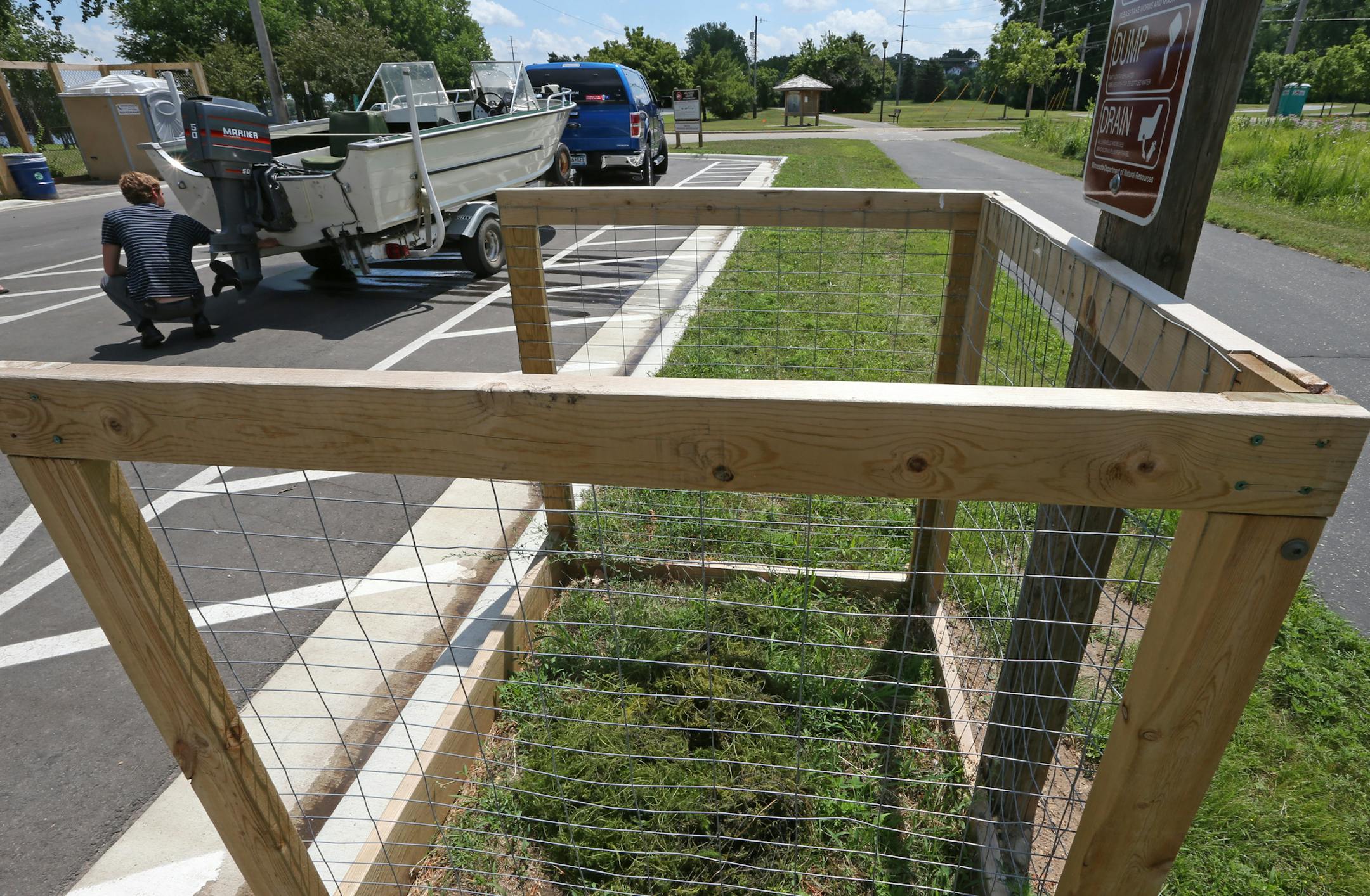 Adam Doll, DNR Watercraft Inspectin Supervisor, demonstrated the correct way to clean a boat of weeds and how to drain live wells during a press conference announcing that the DNR is setting up 200 new clean and drain areas at boat launches around the state. They are hoping the cleaning areas will slow the spread of invasive species. Photographed on 7/16/13 at the Jaycee Park boat landing in Hastings, MN.] Bruce Bisping/Star Tribune bbisping@startribune.com Adam Doll/source.