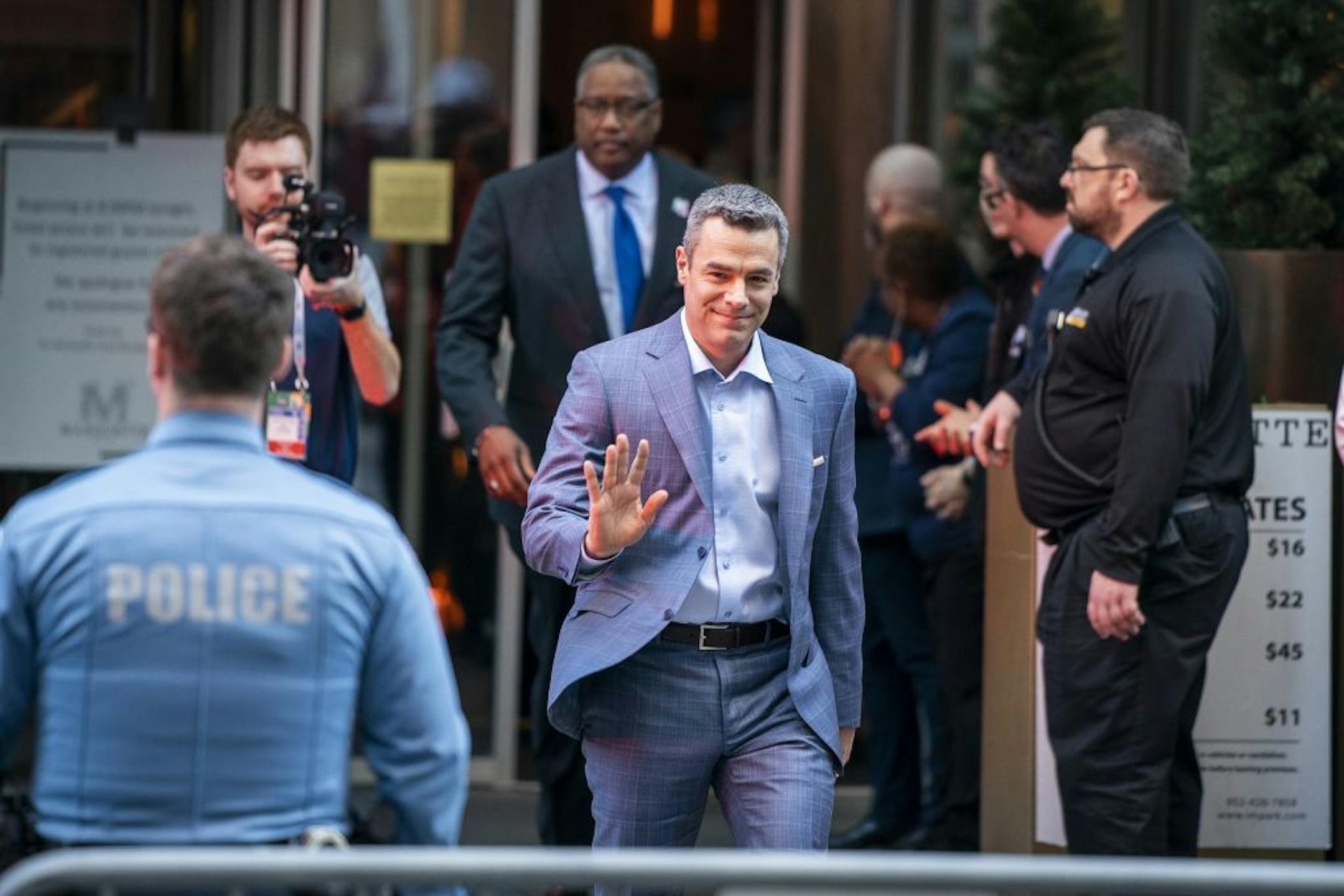 University of Virginia basketball head coach Tony Bennett waves to fans as he leaves the Marquette Hotel to board the bus.