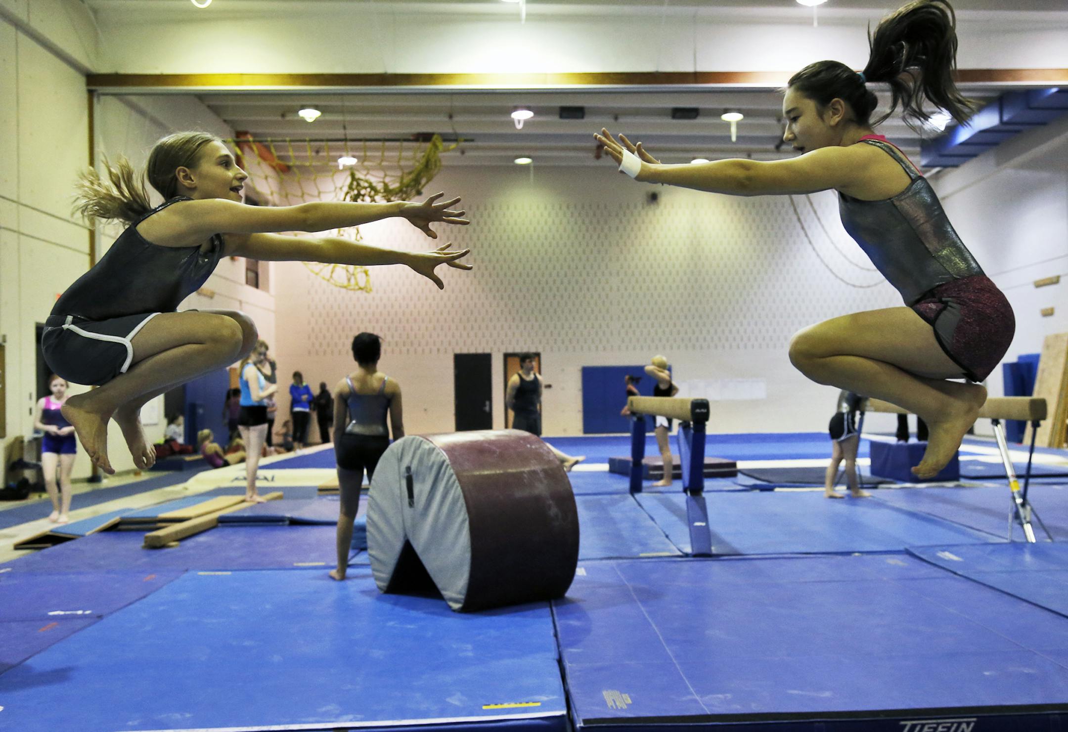 Aris Iwaszko, 12, left, and Elizabeth Webster, 12, both members of the South/Roosevelt team, worked out on a low beam. Now that the city schools have a facility, the goal has become to be competitive with the top programs in the area.