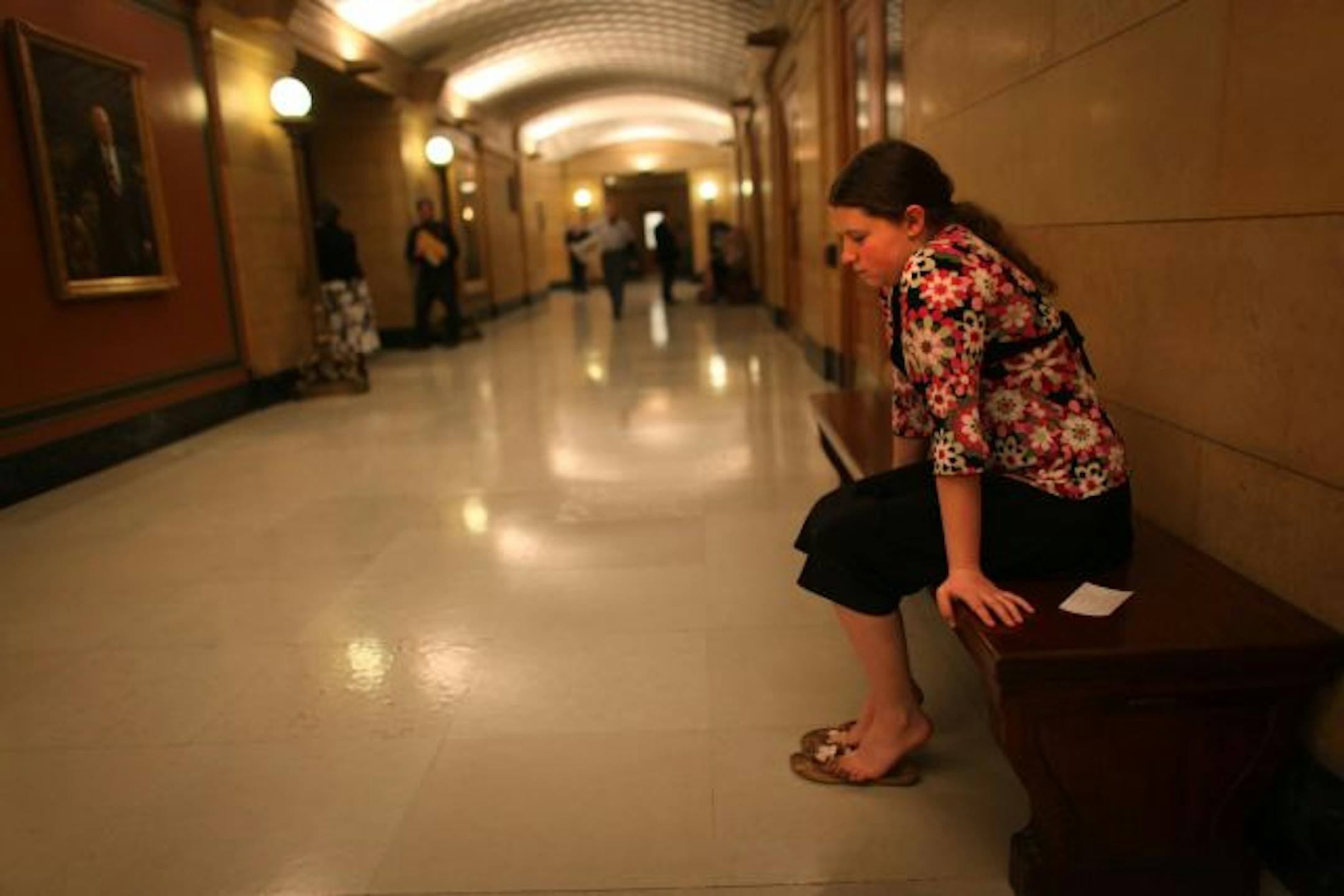 Kayla Meyer, who gave up hockey after her injuries, rested in a hallway after testifying in support of a bill for concussion standards.