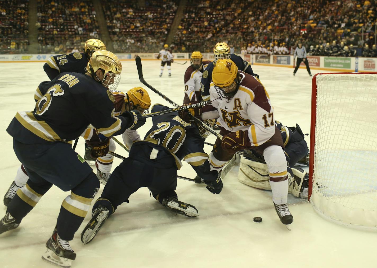 The Gophers' Seth Ambroz was tangled up in blue while trying to get a handle on a loose puck next to the Fighting Irish net during a 2014 game. Now the teams will be conference rivals.