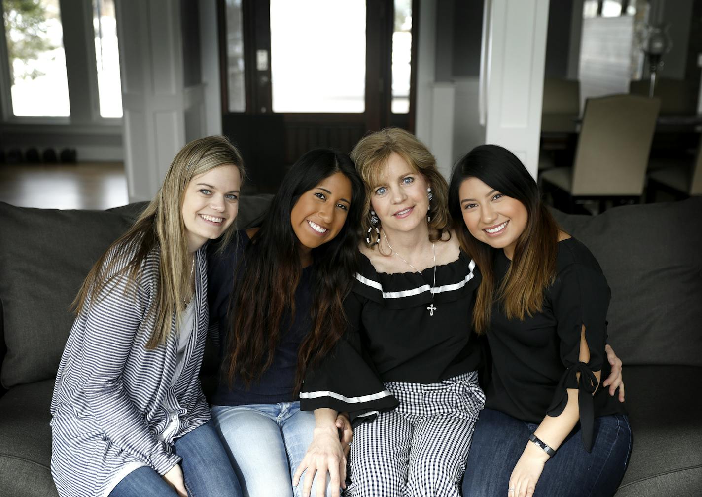 Julie Ledy, second from right, founder of the nonprofit "Adoption is Love" poses for a photo with her daughters Jenna Huiras, from left, 29, Chloe Ledy, 17, and Jillian Ledy, 20. ] LEILA NAVIDI &#xef; leila.navidi@startribune.com BACKGROUND INFORMATION: Julie Ledy, founder of the nonprofit "Adoption is Love" puts together birthday bags for foster kids with her daughters in her Roseville home on Friday, March 23, 2018.