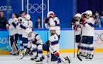 The United States team watches as Canada players celebrate after winning the women’s gold medal hockey game.