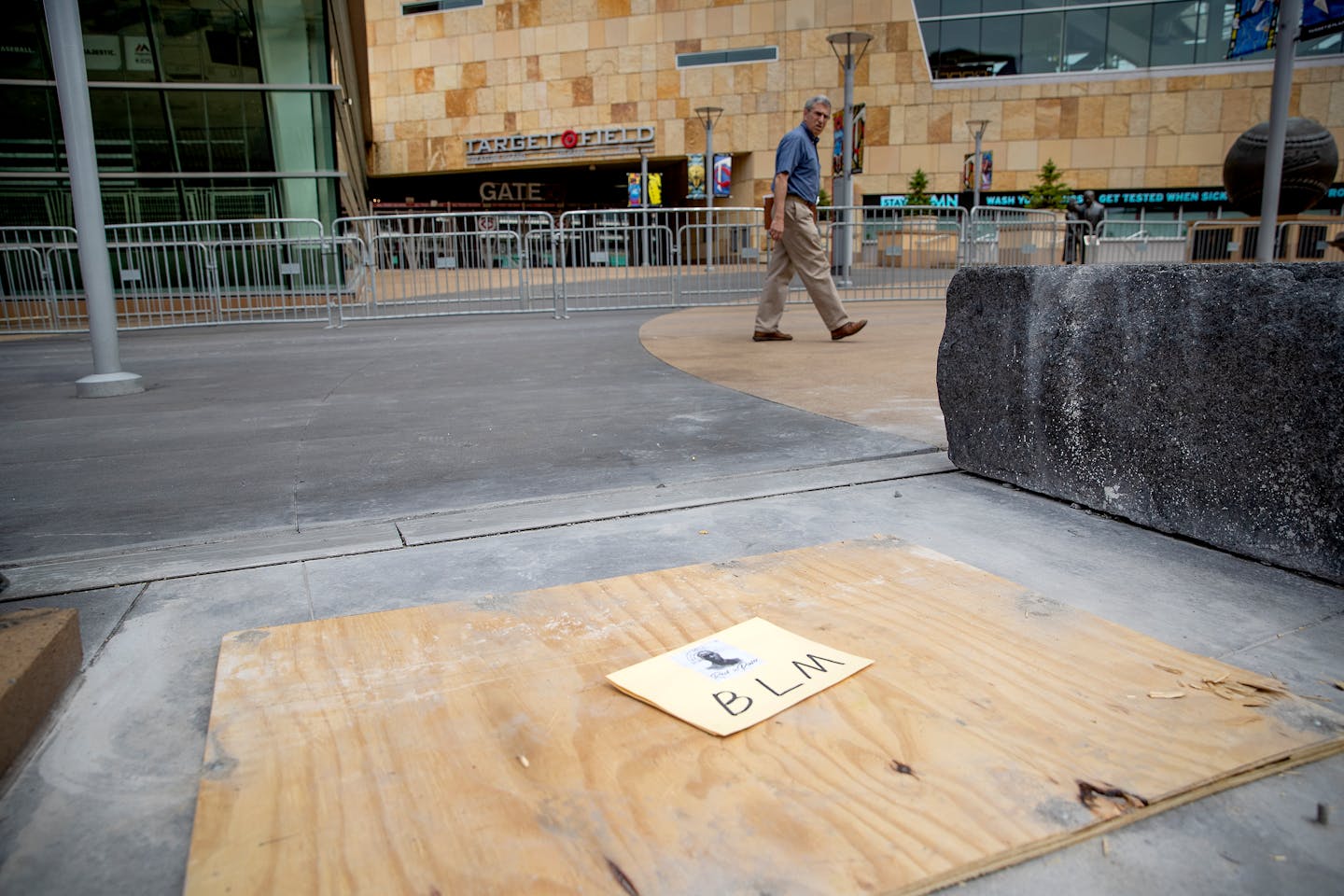 A passerby looks back where a statue of former Twins owner Calvin Griffith stood outside Target Field