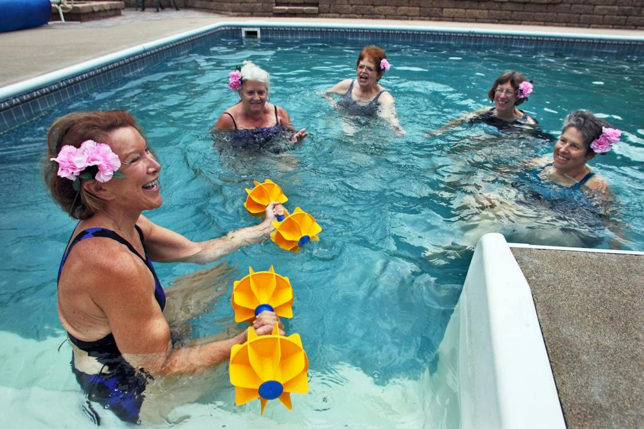 Wendy Louise leads a aqua-aerobics 'sing-along' class working with water weights at L A Fitness. Louise, left, recently led a smaller group at a Bloomington neighborhood pool.