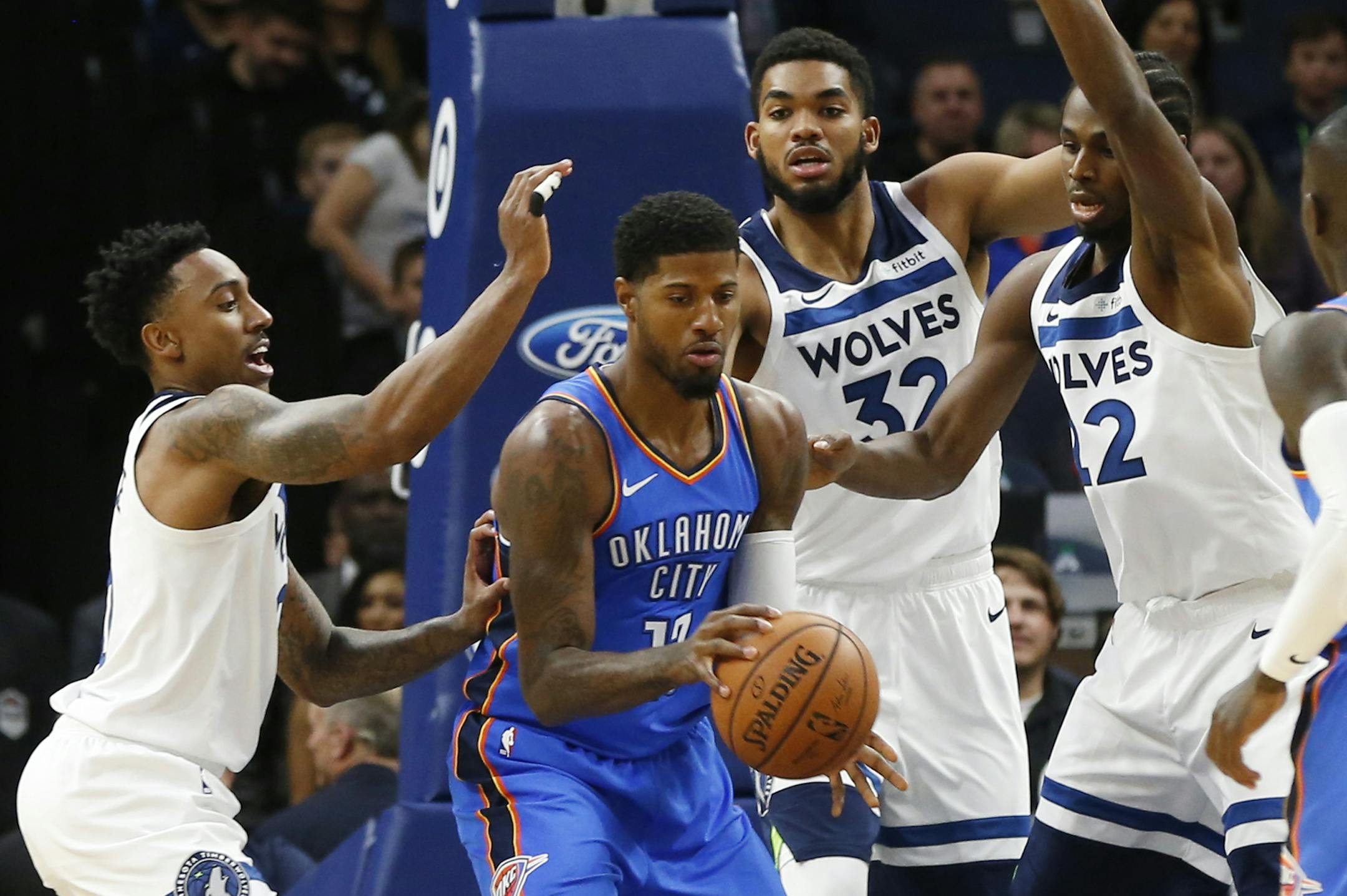 Oklahoma City Thunder's Paul George, second from left, finds himself surrounded by Minnesota Timberwolves, from left, Jeff Teague, Karl-Anthony Towns and Andrew Wiggins during the first half of an NBA preseason basketball game Friday, Oct. 5, 2018, in Minneapolis. (AP Photo/Jim Mone)