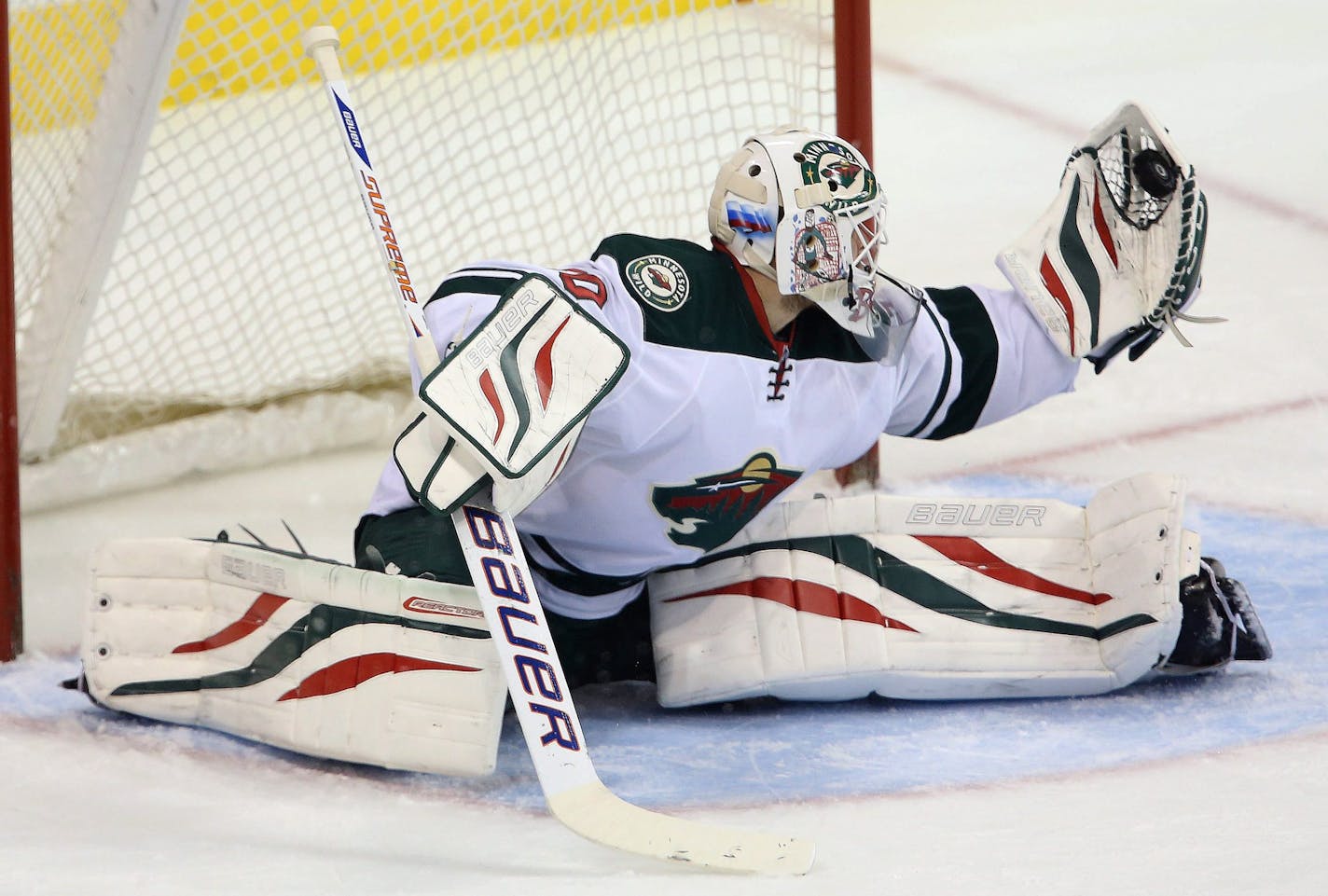 Minnesota Wild's Ilya Bryzgalov (30) makes a quick glove save against the Winnipeg Jets' during first period NHL hockey action in Winnipeg, Manitoba, Monday, April 7, 2014. (AP Photo/The Canadian Press, Trevor Hagan)