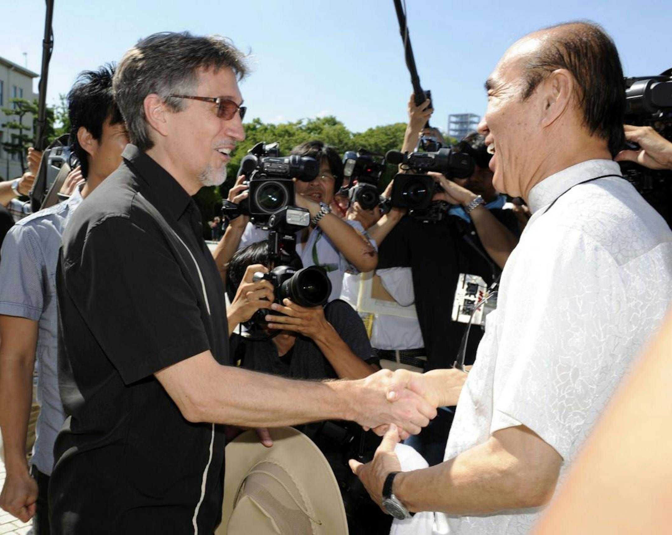 Clifton Truman Daniel, left, a grandson of former U.S. President Harry Truman, is greeted by Japanese peace activist Masahiro Sasaki who arranged Daniels' first visit to Japan, at the Hiroshima Peace Memorial Park in Hiroshima, Japan, Saturday, Aug. 4, 2012. Daniel laid a wreath at the park Saturday for the 140,000 people killed by the Aug. 6, 1945 bombing authorized by his grandfather. (AP Photo/Kyodo News) JAPAN OUT, MANDATORY CREDIT, NO LICENSING IN CHINA, HONG KONG, JAPAN, SOUTH KOREA AND FR