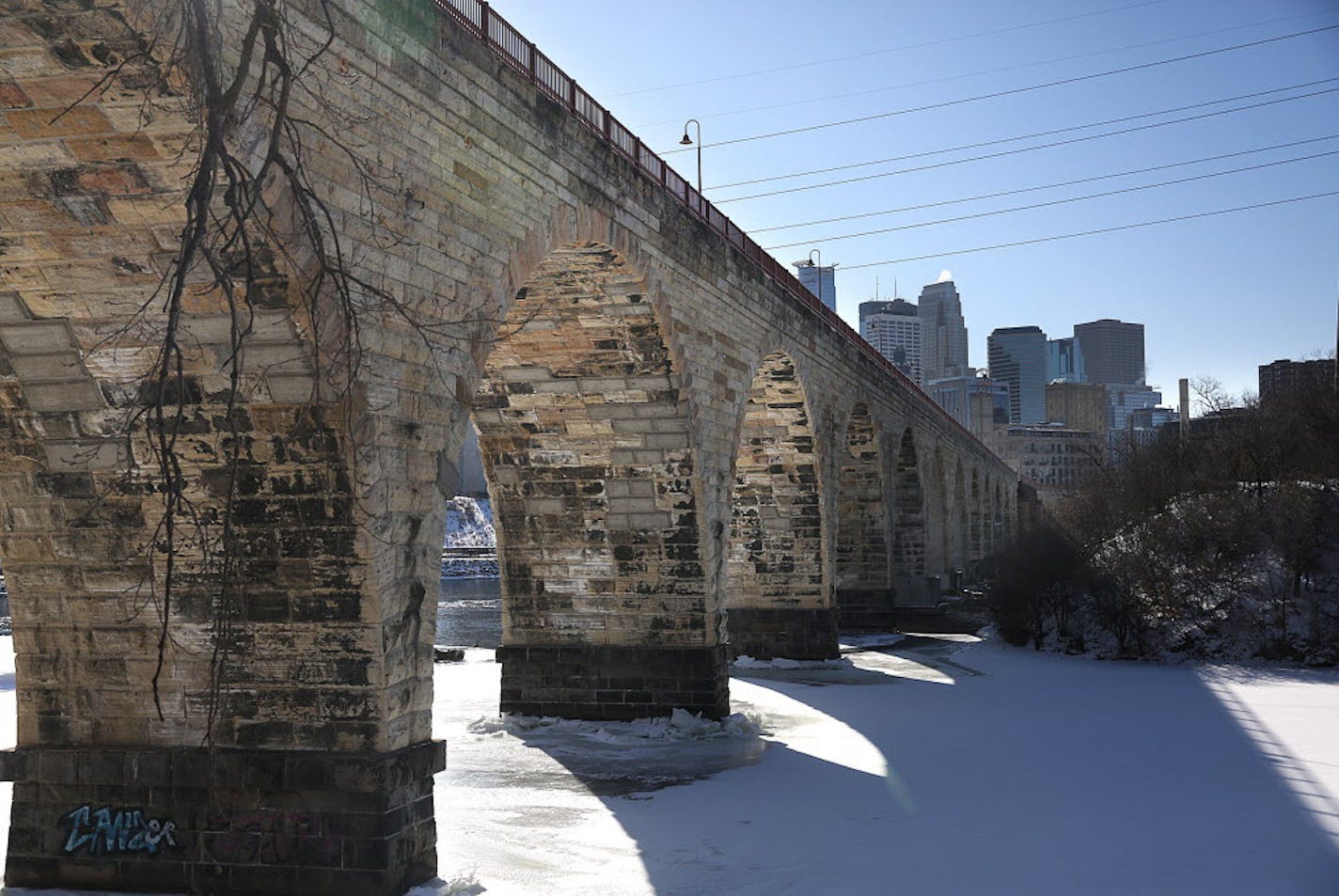 The Minneapolis skyline provides a picturesque backdrop for the historic Stone Arch Bridge, along the Mississippi River. ] JIM GEHRZ &#xef; james.gehrz@startribune.com / Minneapolis, MN / March 5, 2015 /2:30 PM &#xf1; BACKGROUND INFORMATION: More than 30 years since a foundational plan for riverfront park development prompted huge changes in the St. Anthony Falls area, a new plan takes stock of what's undone, urges correcting what was done wrong and adds new ideas.