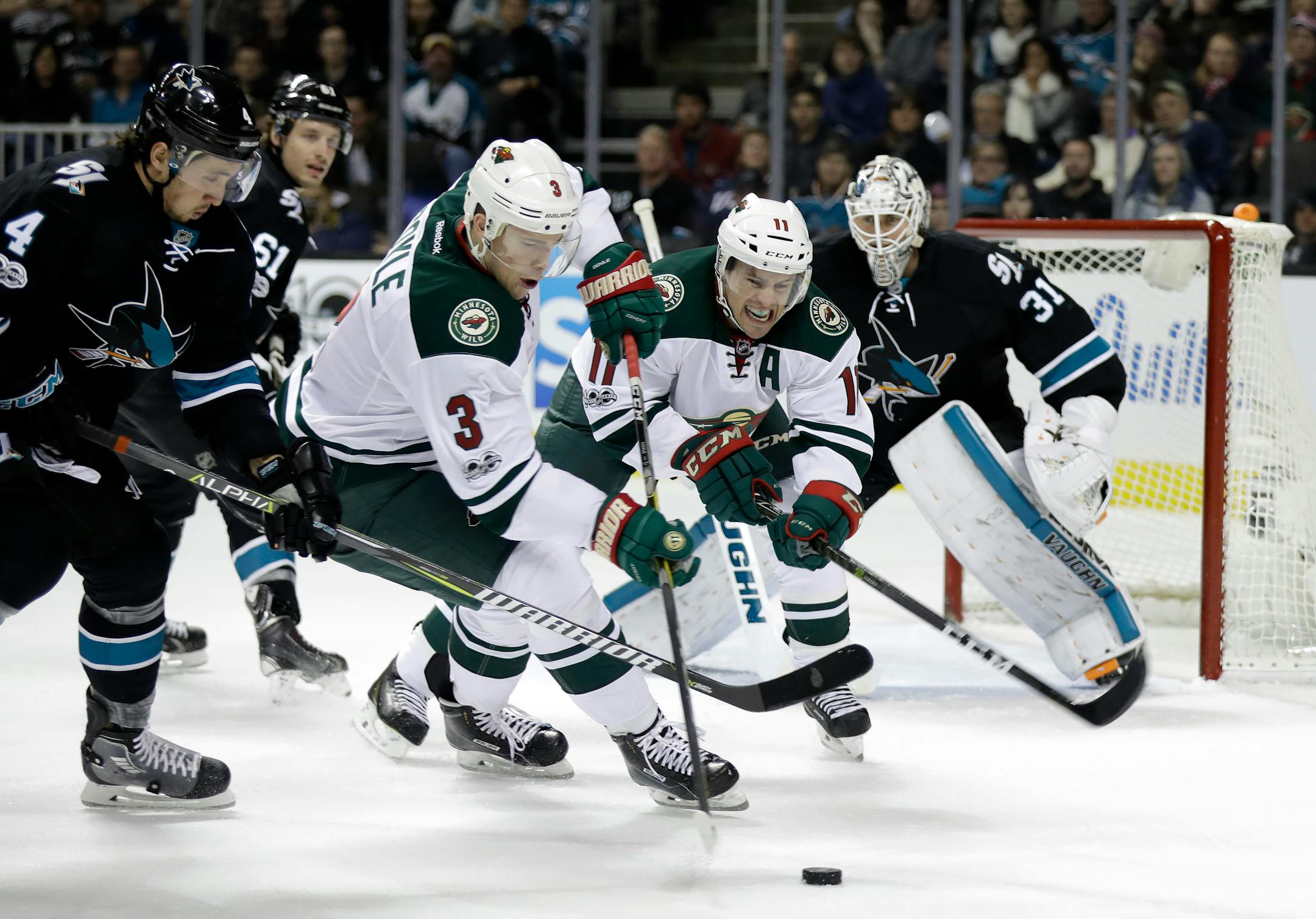 Minnesota Wild's Charlie Coyle (3) reaches for the puck next to San Jose Sharks' Brenden Dillon (4) during the second period of an NHL hockey game Thursday, Jan. 5, 2017, in San Jose, Calif. (AP Photo/Marcio Jose Sanchez)