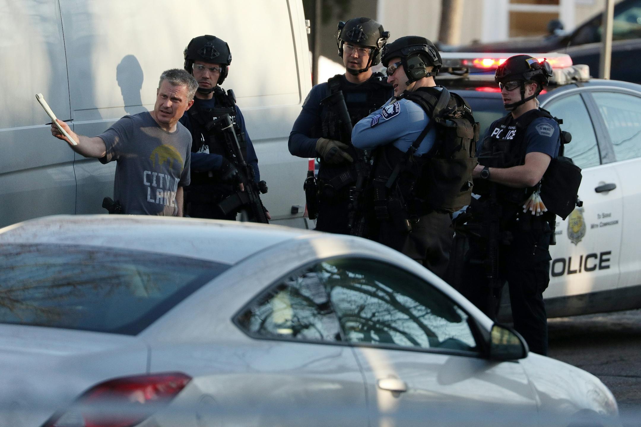Police in tactical gear conferred with one another before entering Patrick Henry High School after a gunman was reported getting off a Metro Transit bus near the school Tuesday.