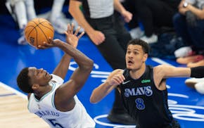 Timberwolves guard Anthony Edwards (5) attempts a fadeaway shot over Mavericks guard Josh Green (8) during the first quarter of Game 2 of the Western