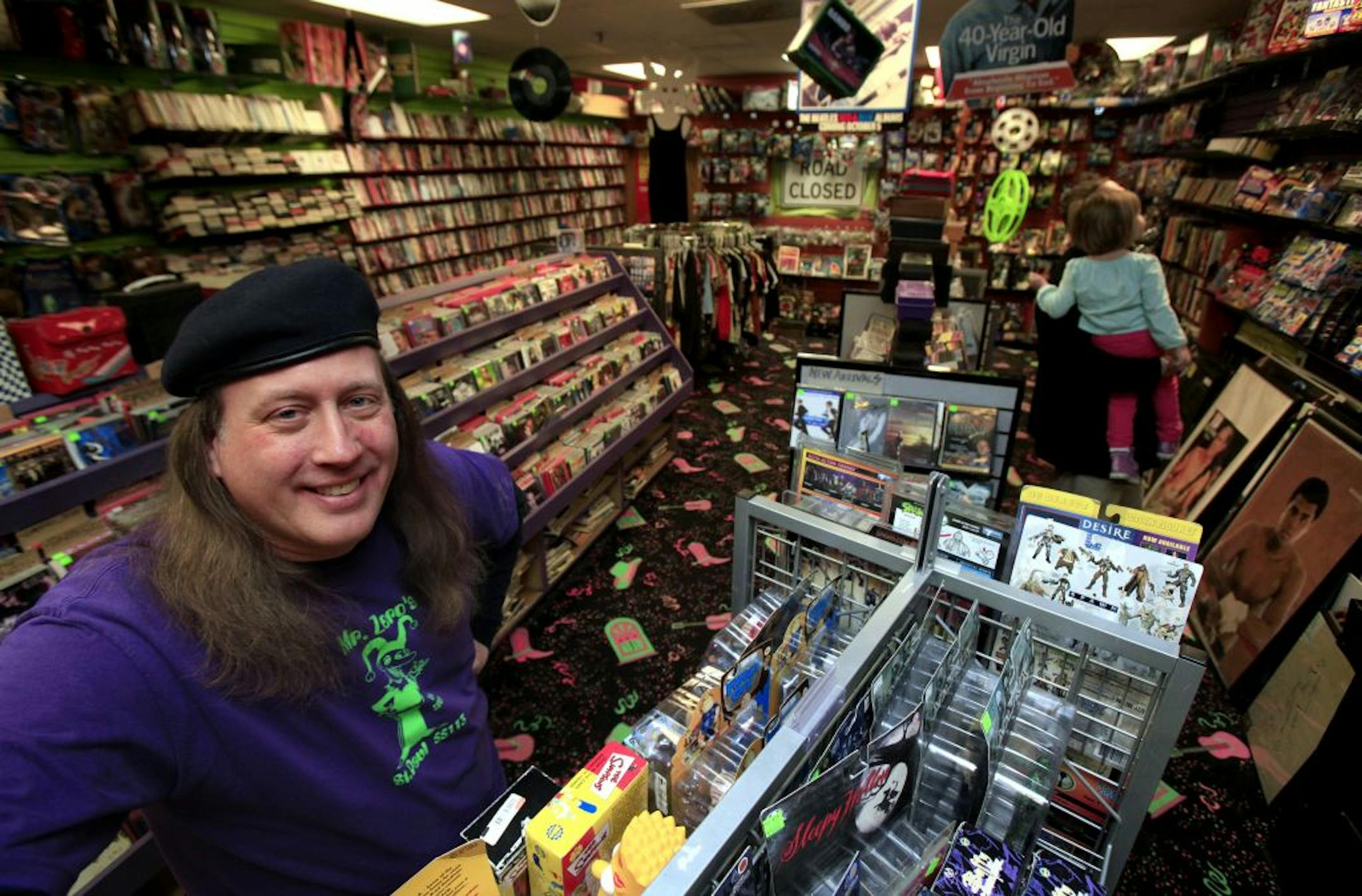 Richard Schwinden owner of Mr. Zero's novelty shop in Roseville, MN. Shoppers Perry Lensing and his 3 year old daughter Chloe Szenay of Roseville browse the shop on January 22, 2013.