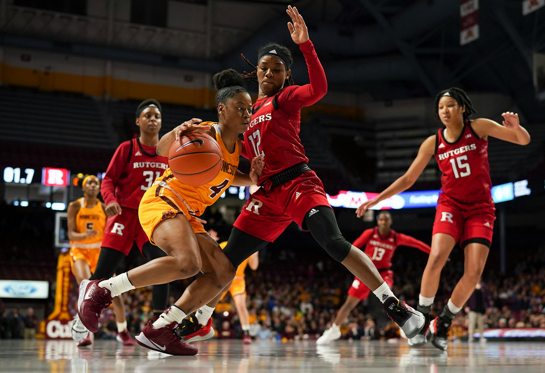 Minnesota Gophers guard Jasmine Powell (4) drove against the defense presented by Rutgers Scarlet Knights guard Khadaizha Sanders (12) in the first quarter.