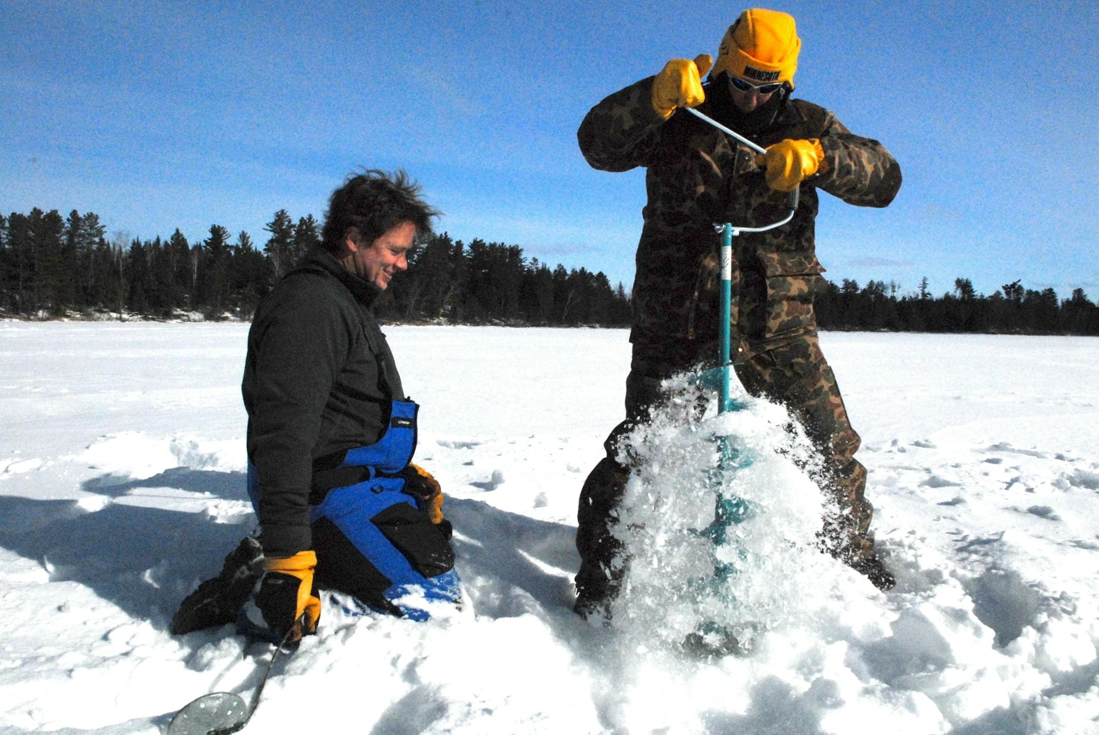 Mark Lindeberg of Stillwater drills a hole through about 3 feet of ice while seeking northern pike on Basswood Lake in the Boundary Waters Canoe Area Wilderness. Todd Snell of Oakdale is at left.