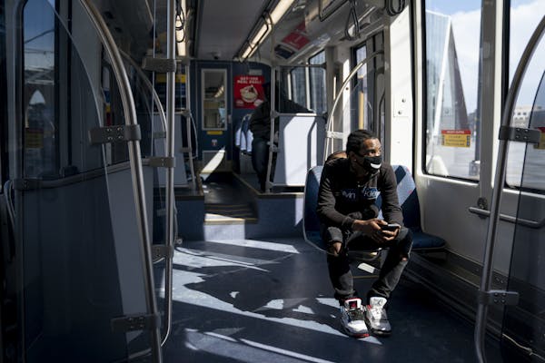 Ocyress Delarosa rides an almost empty Light Rail during the p.m. rush hour to meet someone in Minneapolis, Monday, April 13, 2020, during the coronav