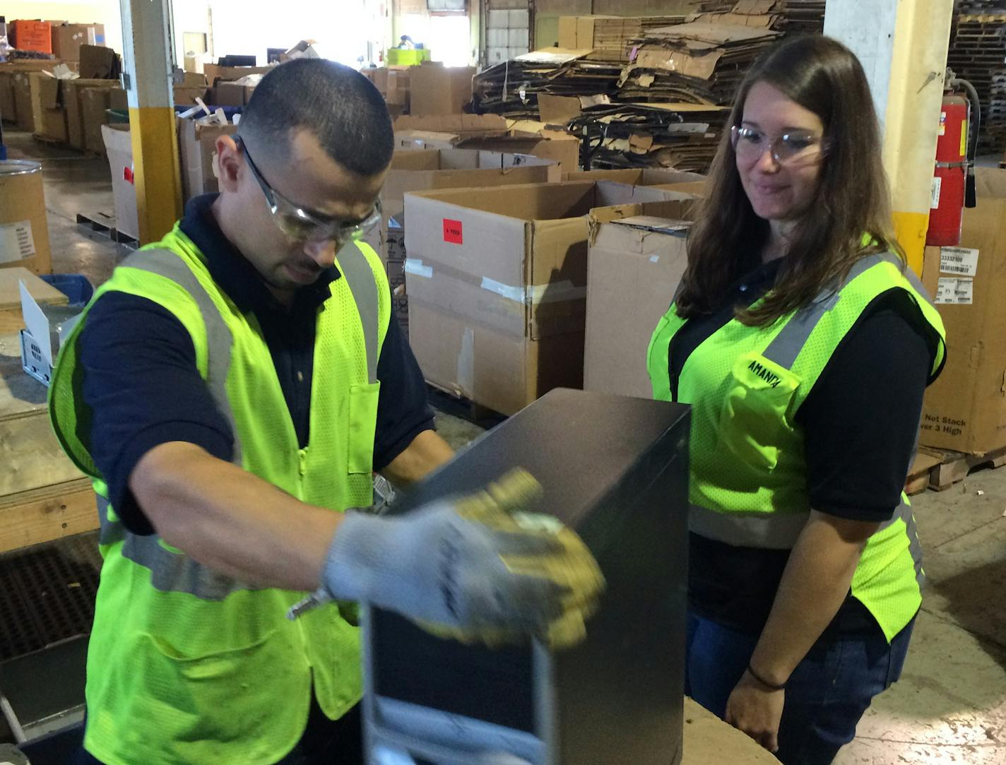 Tech Dump technician Manuel Santos and CEO Amanda LaGrange, a former General Mills accountant with a passion for reuse and redusing waste, begin to dissassemble a personal computer at Tech Dump's plant in St. Paul's Midway District. Photo by Neal.St.Anthony@startribune.com.