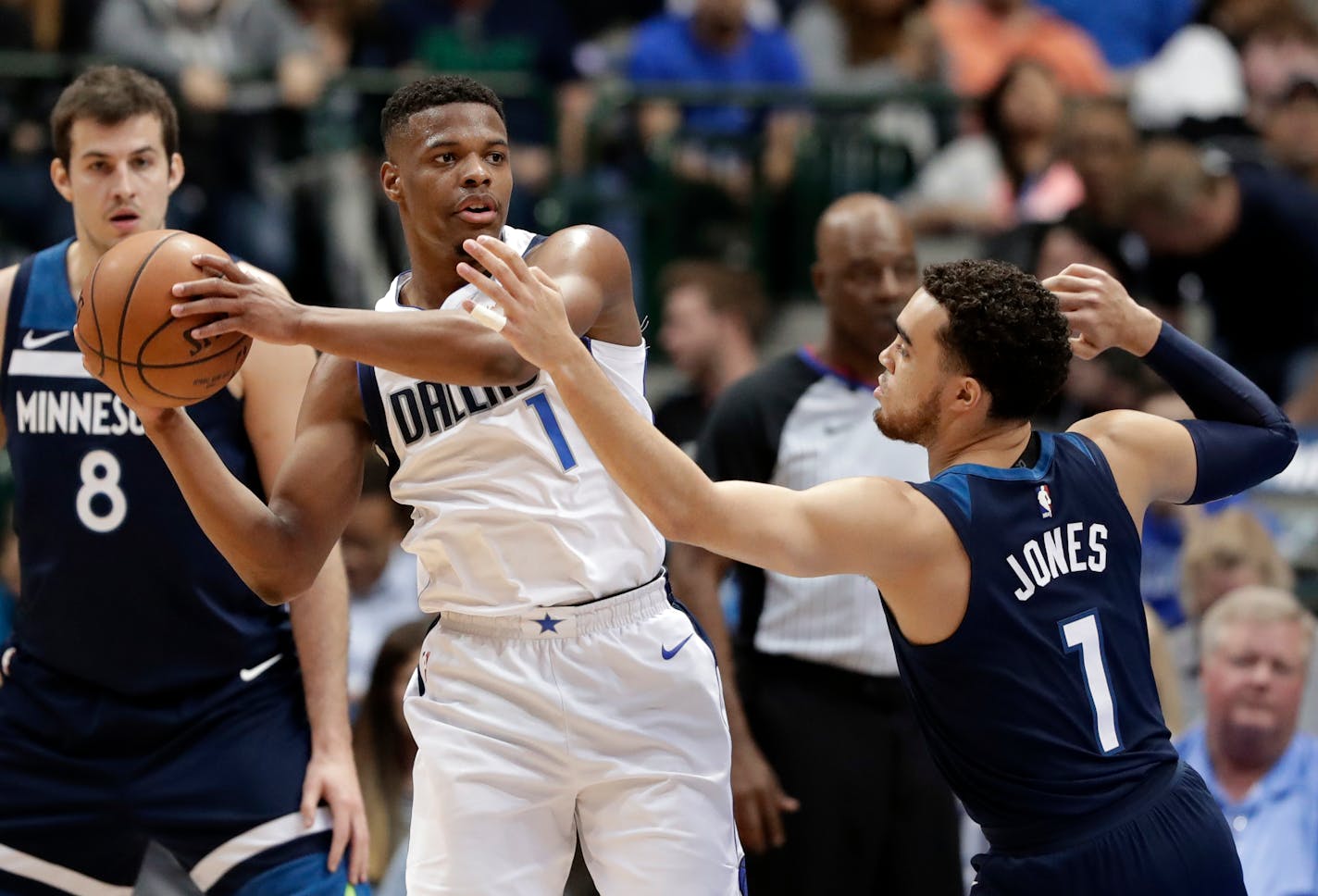 Dallas Mavericks guard Dennis Smith Jr., left, looks to make a pass as Minnesota Timberwolves guard Tyus Jones (1) defends in the first half of NBA basketball game in Dallas, Friday, March 30, 2018. (AP Photo/Tony Gutierrez)