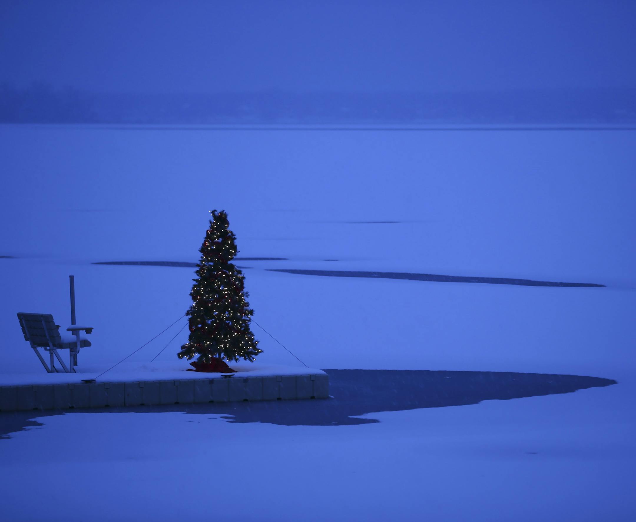 A Christmas tree on a dock in White Bear Lake in the snow Monday evening.